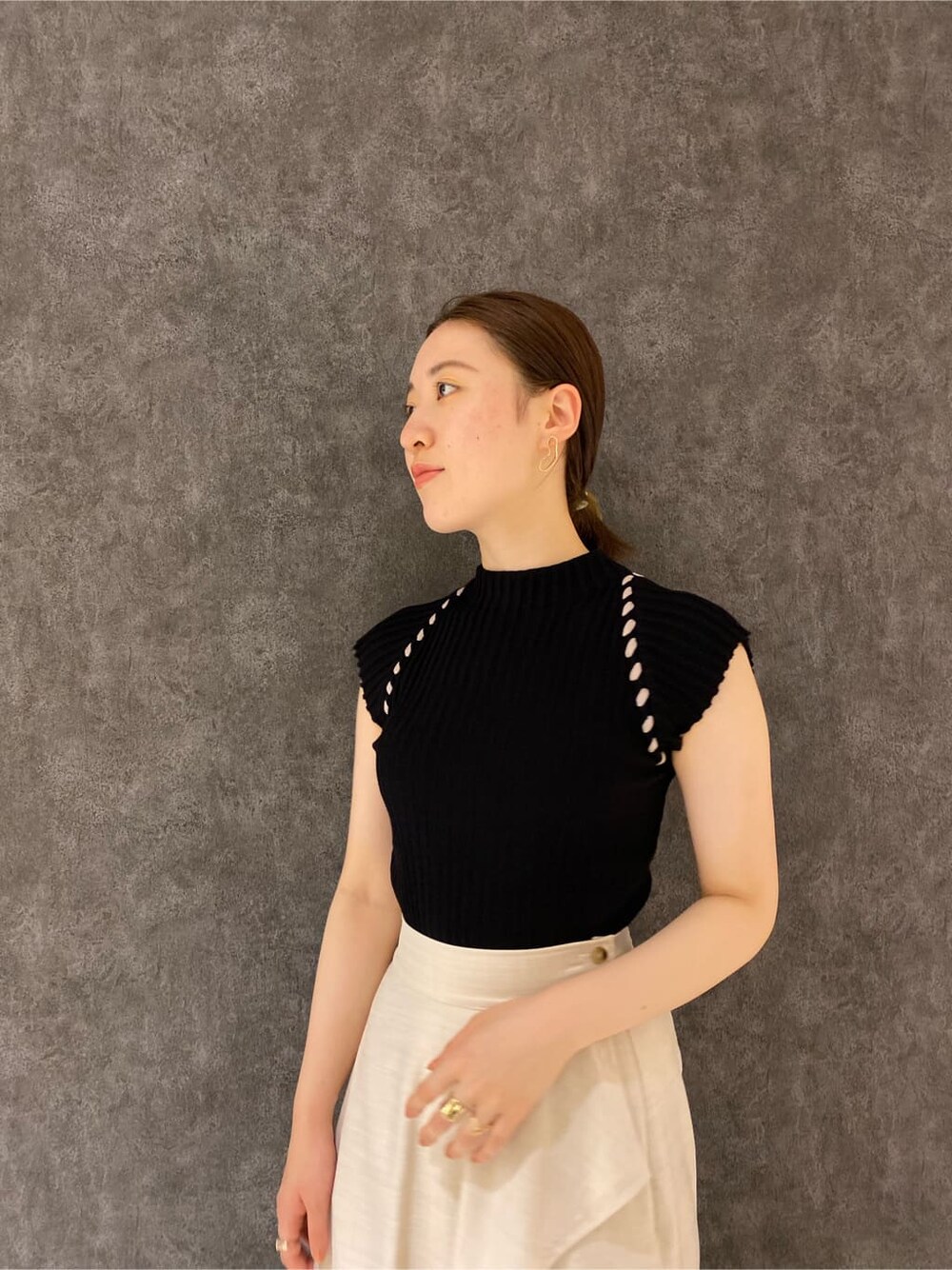 ブラウン系のパンプス、ホワイト系のスカート、ブラック系のニット/セーターを着用したレディースの夏コーディネートの3枚目の写真