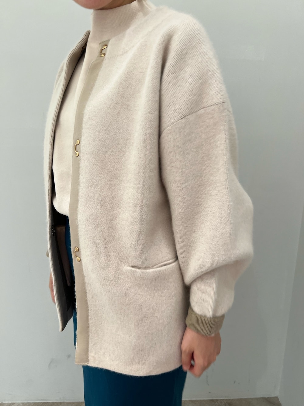 ベージュ系のブーツ、ホワイト系のカーディガン/ボレロ、ホワイト系のニット/セーターを着用したレディースの秋コーディネートの3枚目の写真