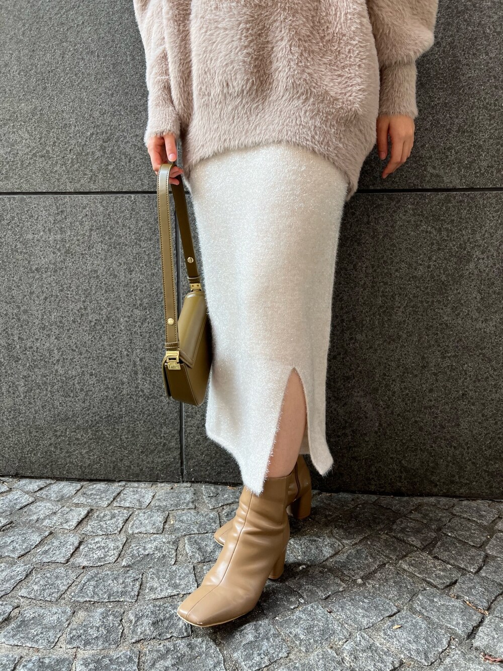 ブラウン系のショルダーバッグ、ブラウン系のニット/セーター、ベージュ系のブーツを着用したレディースの冬コーディネートの7枚目の写真