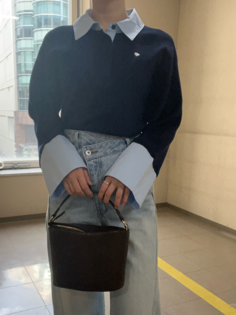 ブルー系のニット/セーター、ブルー系のデニムパンツを着用したレディースの冬コーディネートの4枚目の写真