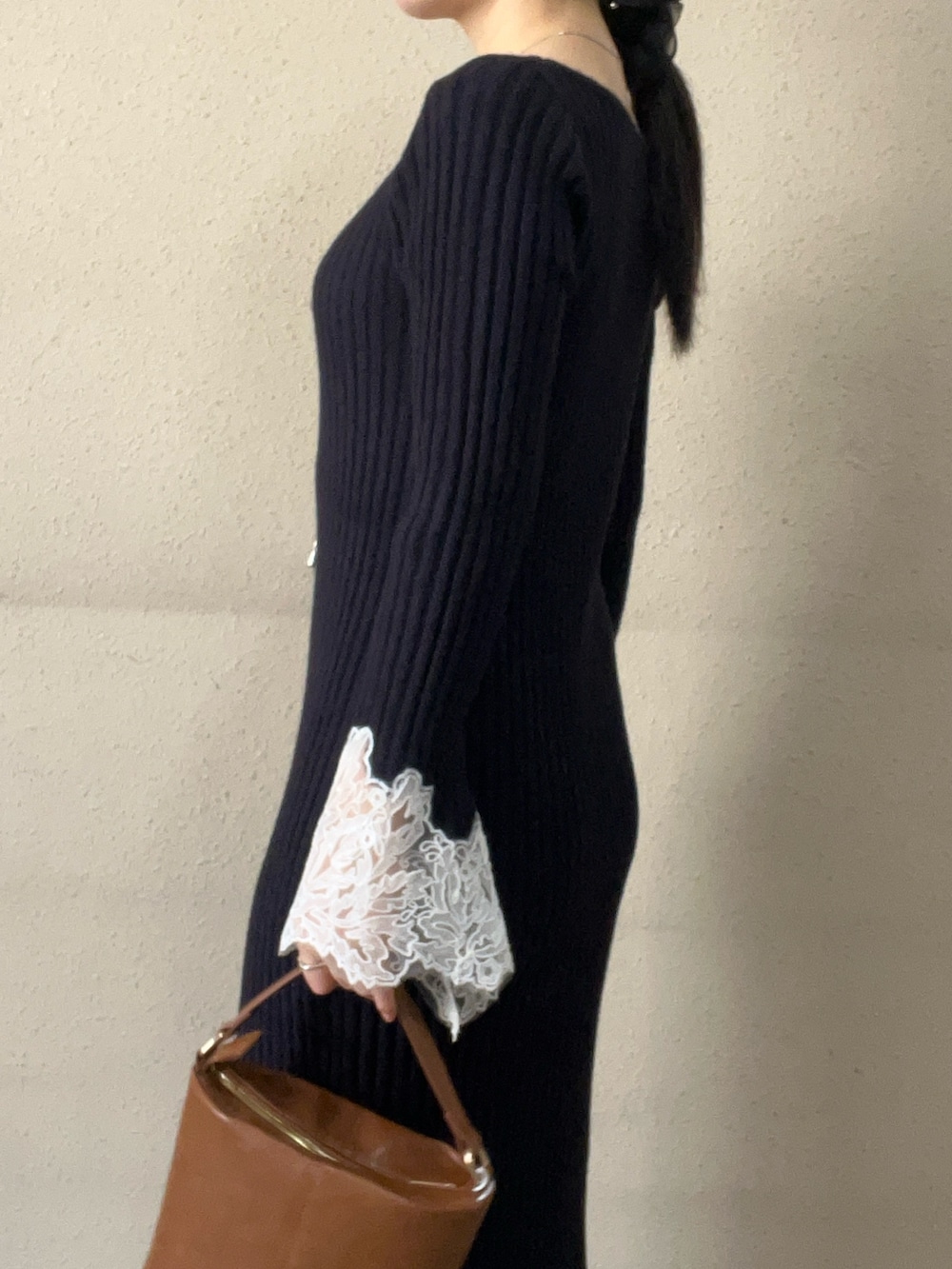 イエロー系のハンドバッグ、ブルー系のワンピース、ブラック系のブーツを着用したレディースの秋コーディネートの5枚目の写真