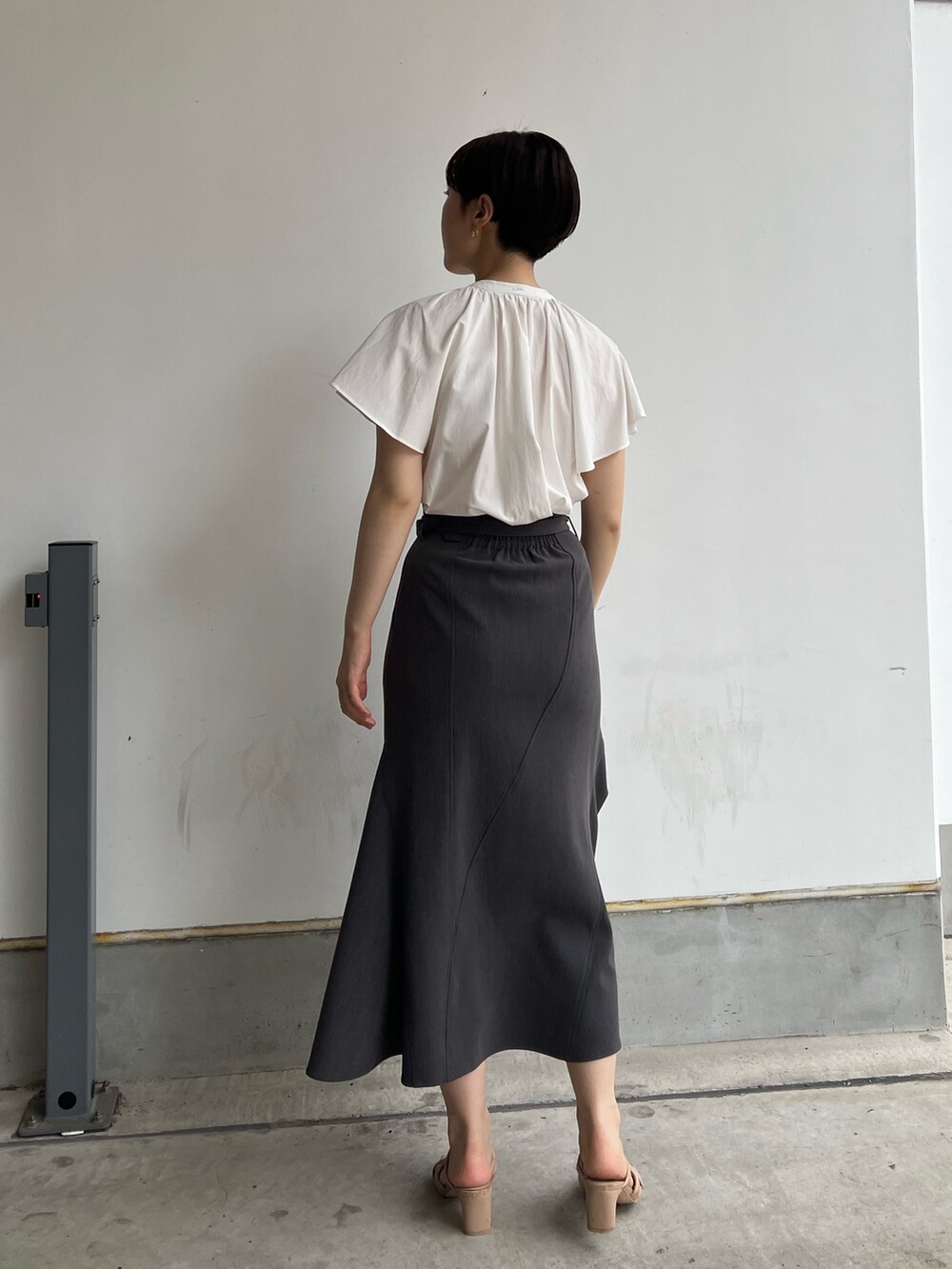 ホワイト系のシャツ/ブラウス、グレー系のスカート、ベージュ系のサンダルを着用したレディースの夏コーディネートの2枚目の写真