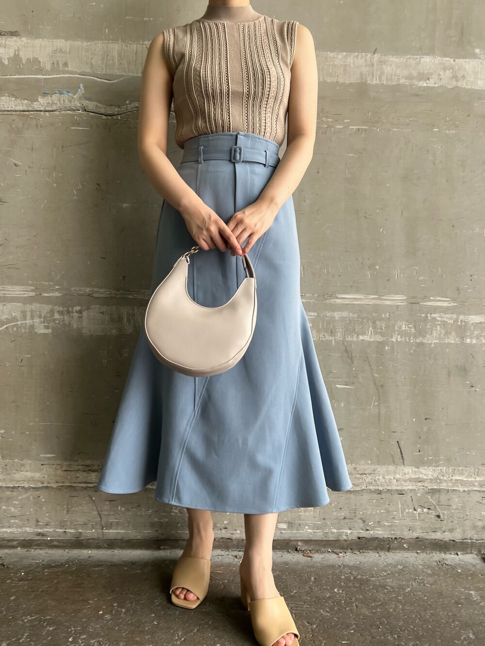 ベージュ系のニット/セーター、ブルー系のスカート、ベージュ系のサンダルを着用したレディースの夏コーディネートの6枚目の写真
