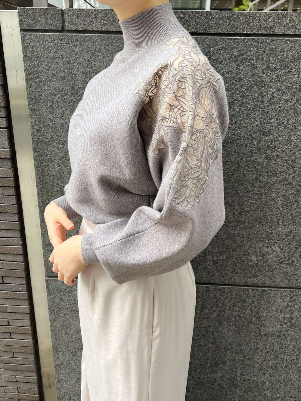 レッド系のブーツ、グレー系のスカート、グレー系のニット/セーターを着用したレディースの冬コーディネートの7枚目の写真