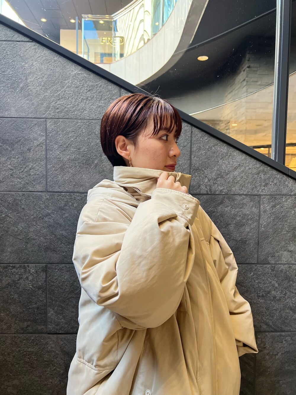 ベージュ系のスニーカー、ブラウン系のスカート、ベージュ系のダウンジャケット/コートを着用したレディースの秋コーディネートの5枚目の写真