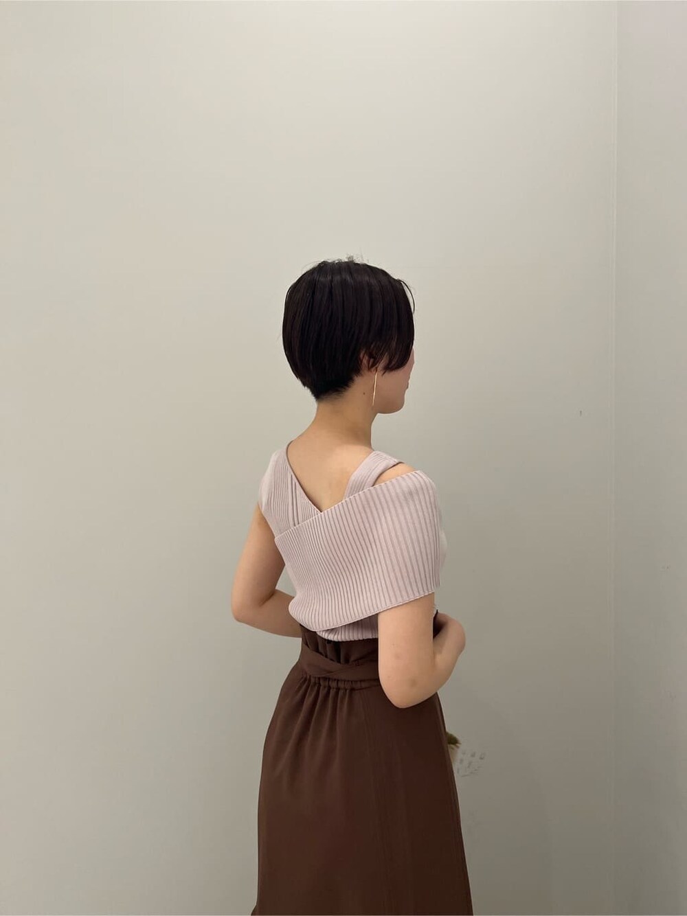 グリーン系のサンダル、ホワイト系のショルダーバッグ、ブラウン系のスカートを着用したレディースの春コーディネートの4枚目の写真