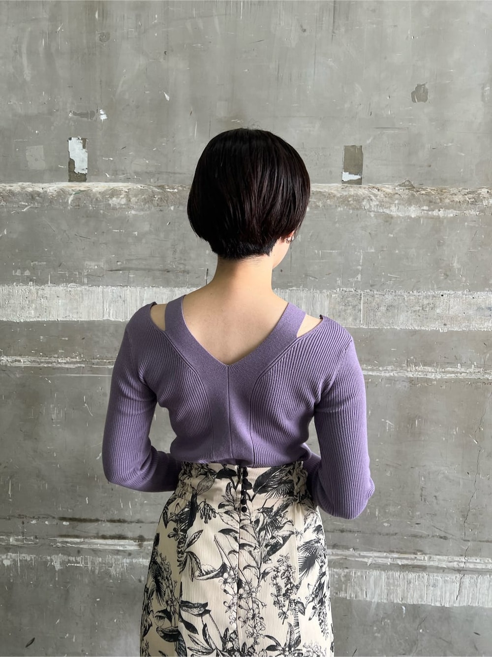 ベージュ系のスカート、ブラック系のブーツ、パープル系のニット/セーターを着用したレディースの秋コーディネートの6枚目の写真