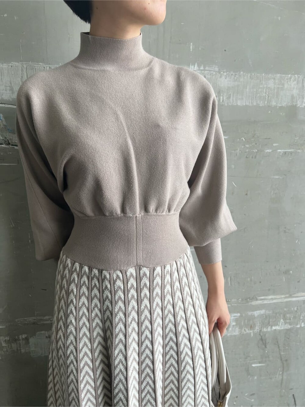 レッド系のブーツ、ベージュ系のワンピース、ホワイト系のハンドバッグを着用したレディースの秋コーディネートの8枚目の写真