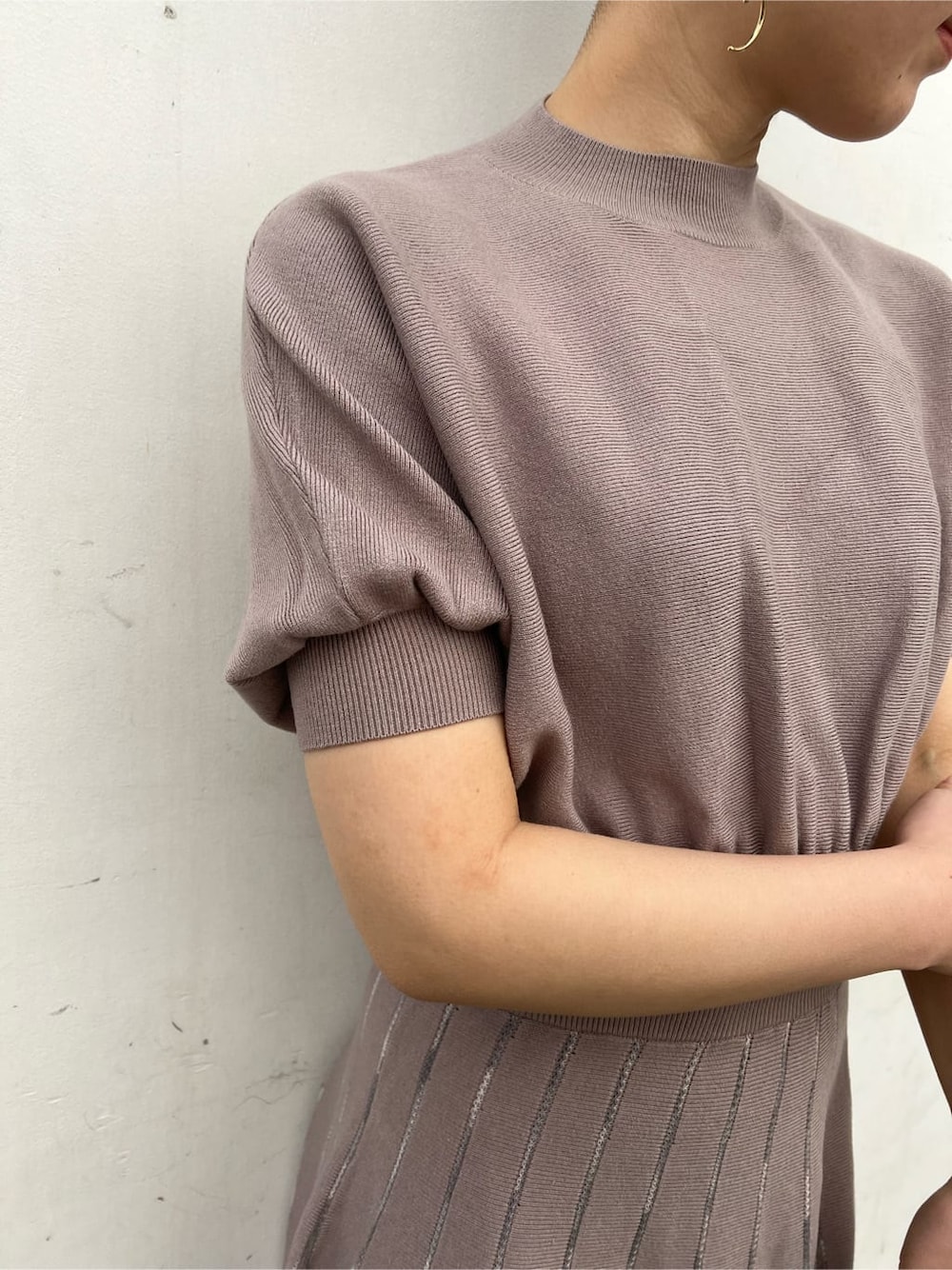 ホワイト系のノーカラーコート、グレー系のワンピース、ホワイト系のサンダルを着用したレディースの冬コーディネートの3枚目の写真