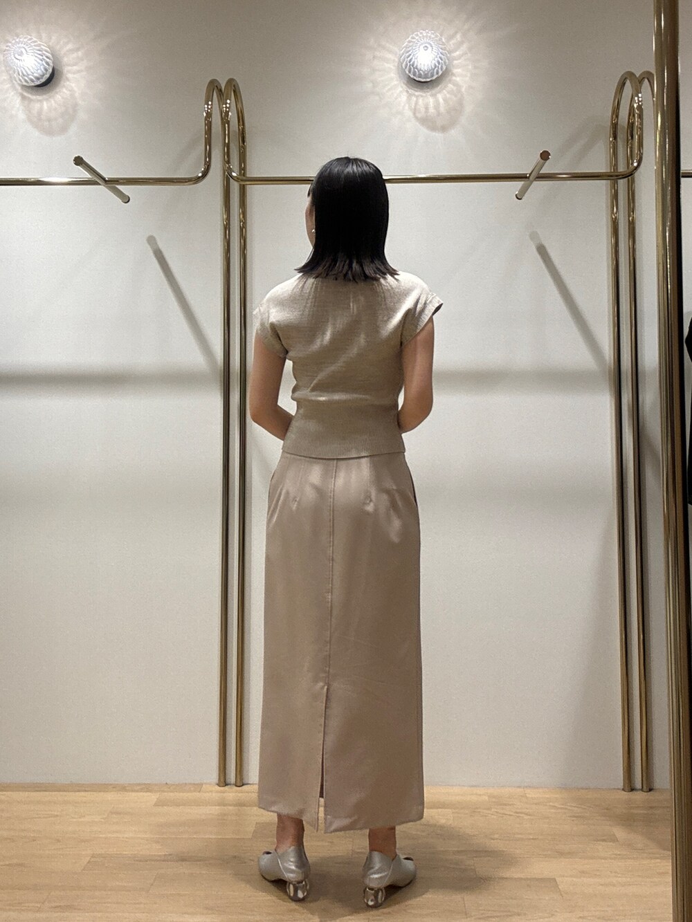 シルバー系のパンプス、ベージュ系のニット/セーター、レッド系のショルダーバッグを着用したレディースの秋コーディネートの3枚目の写真