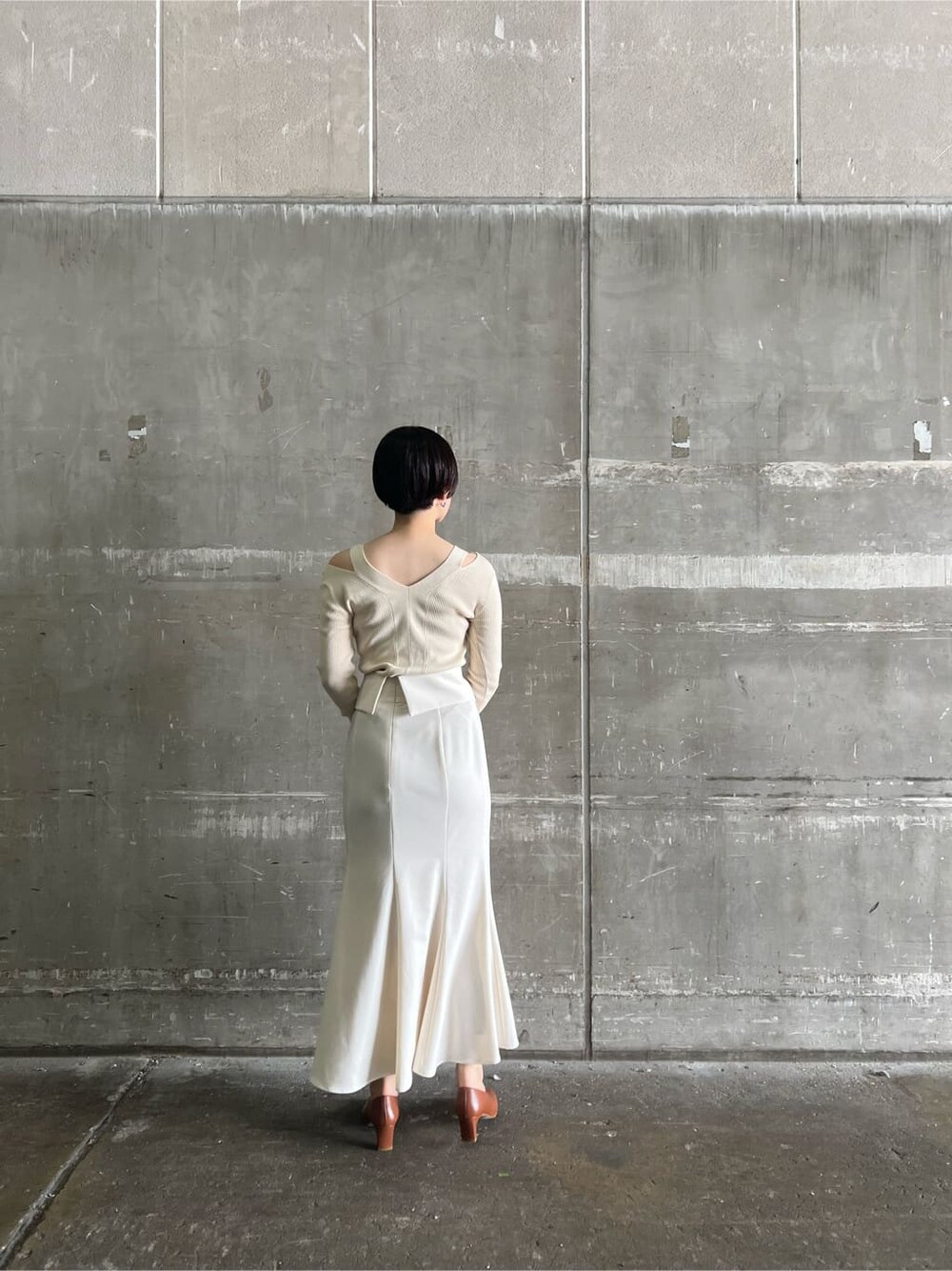 ブラウン系のパンプス、ホワイト系のスカート、ホワイト系のニット/セーターを着用したレディースの夏コーディネートの2枚目の写真