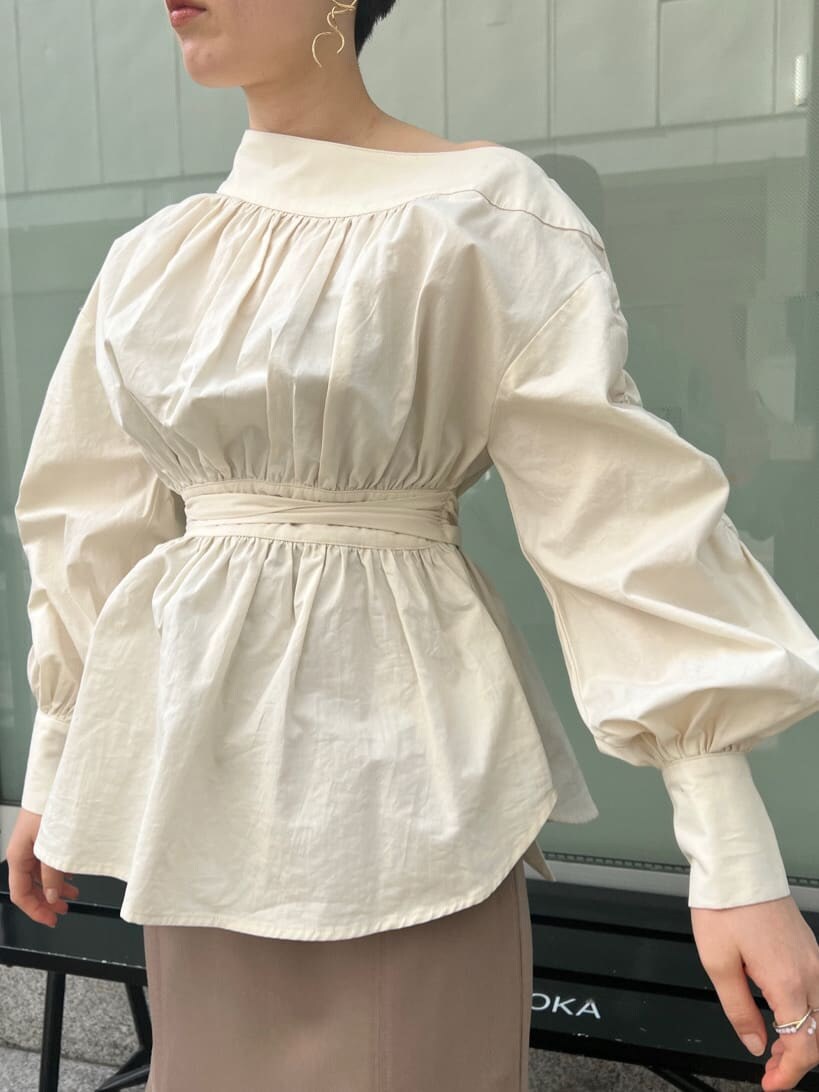 ベージュ系のスカート、ホワイト系のシャツ/ブラウス、ホワイト系のパンプスを着用したレディースの冬コーディネートの5枚目の写真