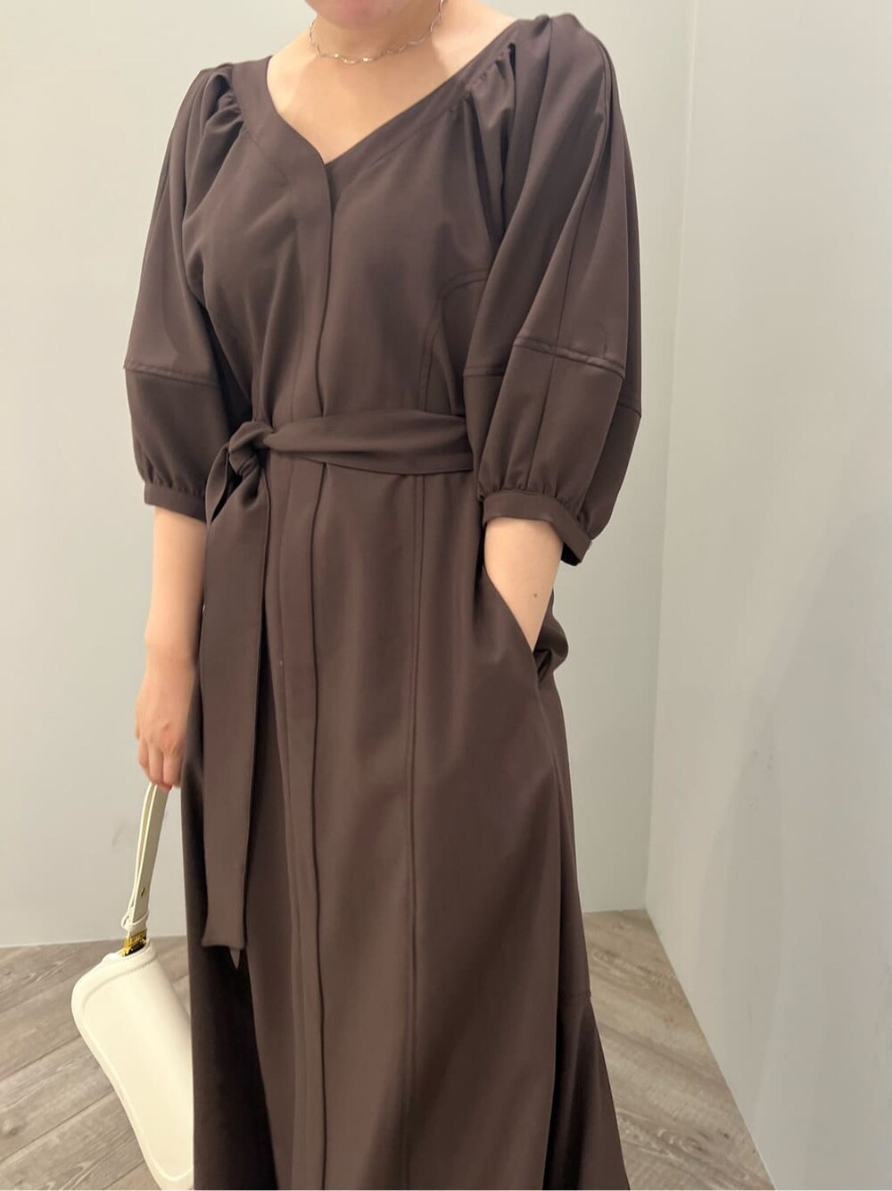 ホワイト系のサンダル、ブラウン系のワンピース、ホワイト系のショルダーバッグを着用したレディースの夏コーディネートの7枚目の写真