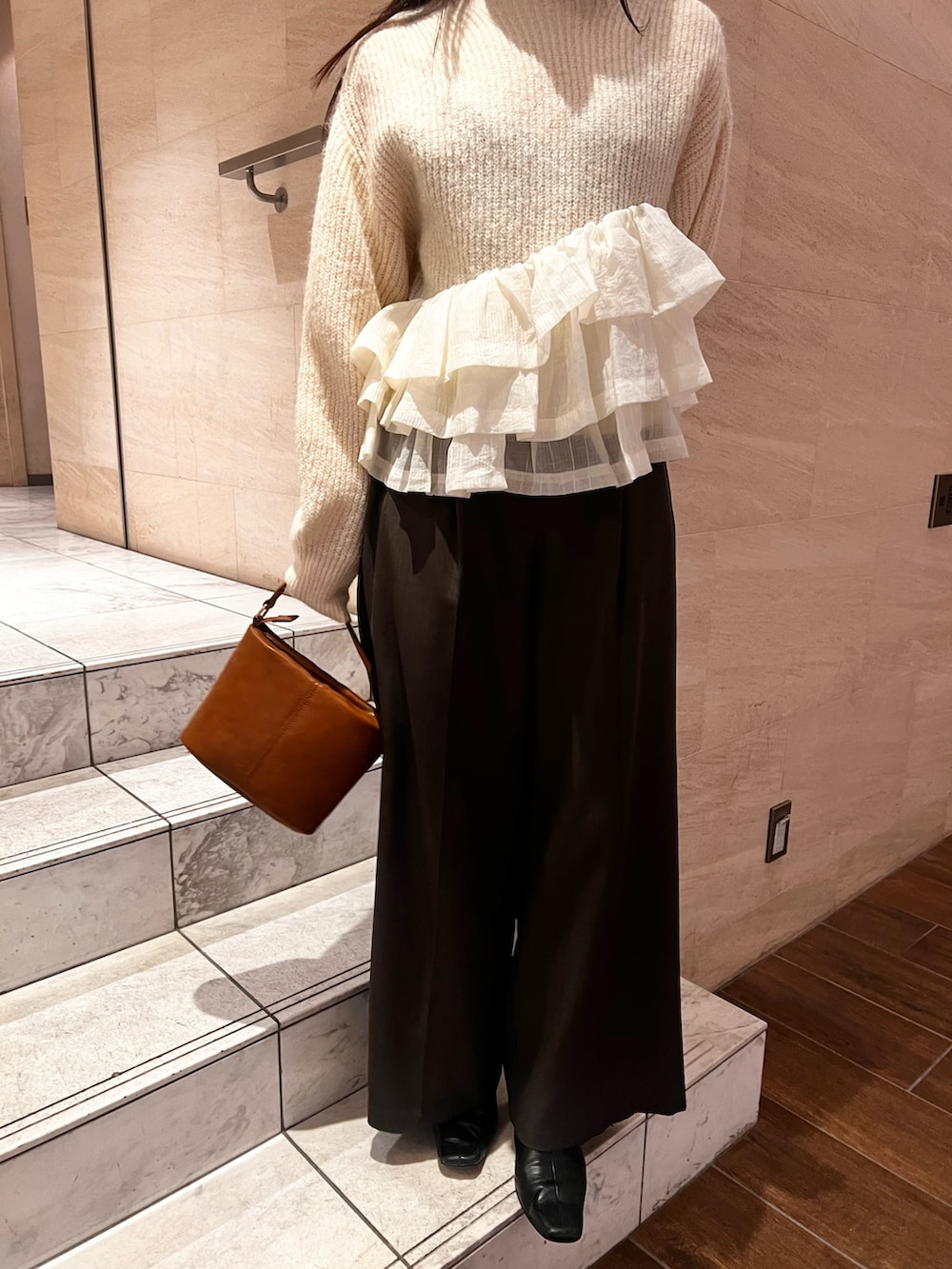 ホワイト系のニット/セーター、グレー系のその他パンツ、イエロー系のハンドバッグを着用したレディースの冬コーディネートの4枚目の写真