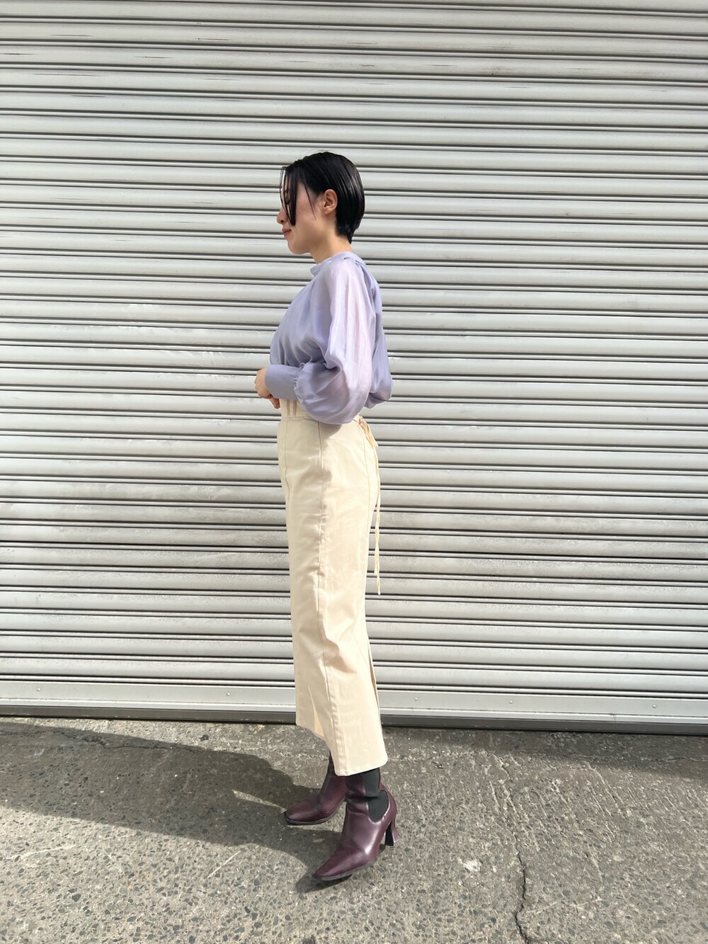 レッド系のブーツ、ホワイト系のスカート、ホワイト系のカーディガン/ボレロを着用したレディースの冬コーディネートの3枚目の写真