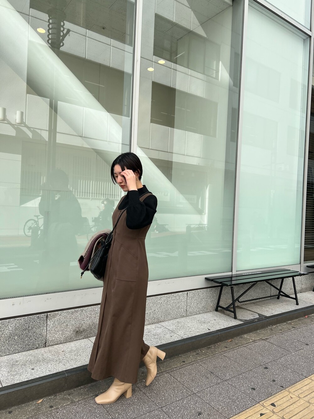 ブラック系のハンドバッグ、ベージュ系のブーツ、ベージュ系のカーディガン/ボレロを着用したレディースの秋コーディネートの3枚目の写真