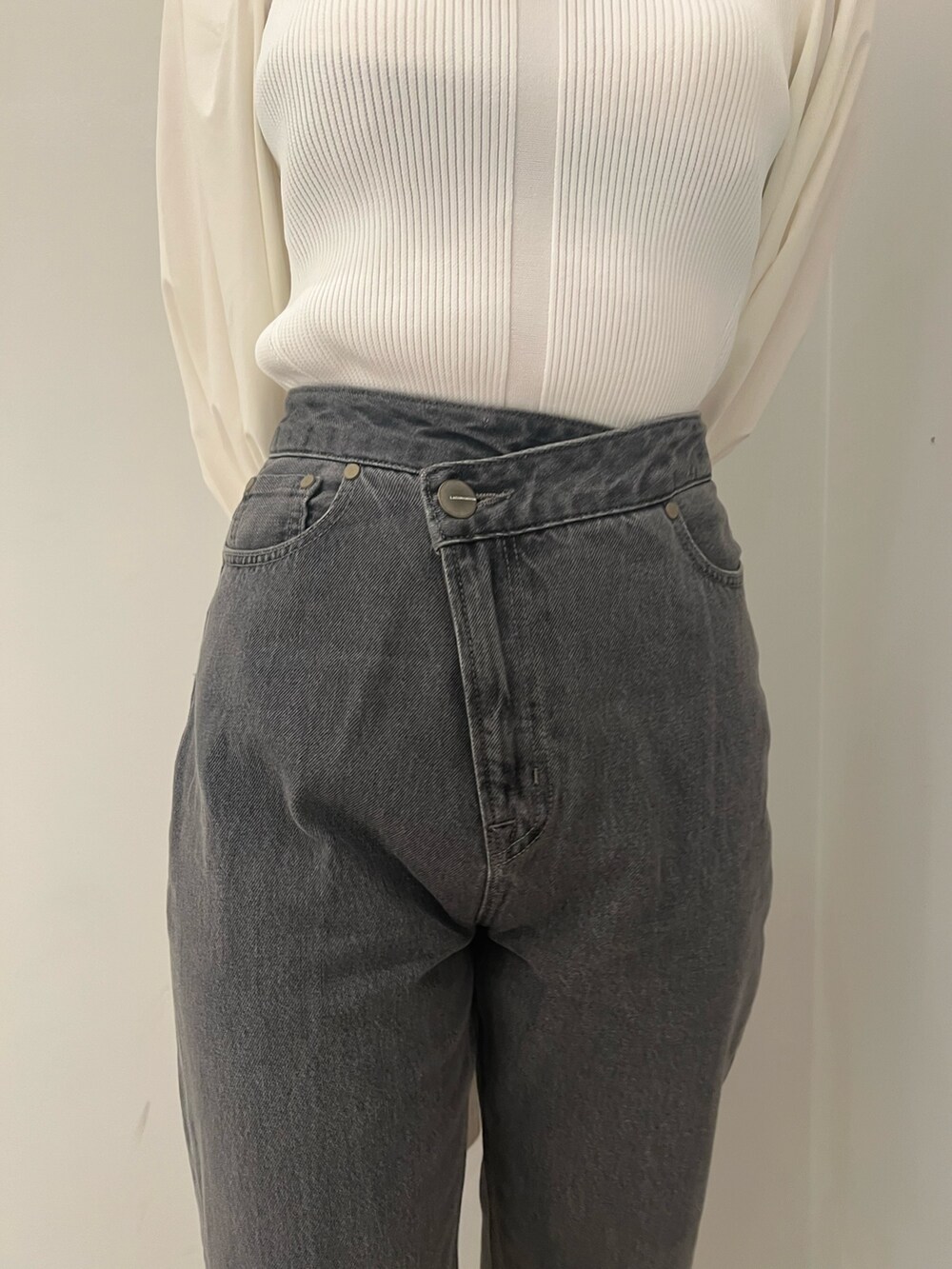 ホワイト系のトレンチコート、ホワイト系のニット/セーター、ブラック系のデニムパンツを着用したレディースの冬コーディネートの10枚目の写真