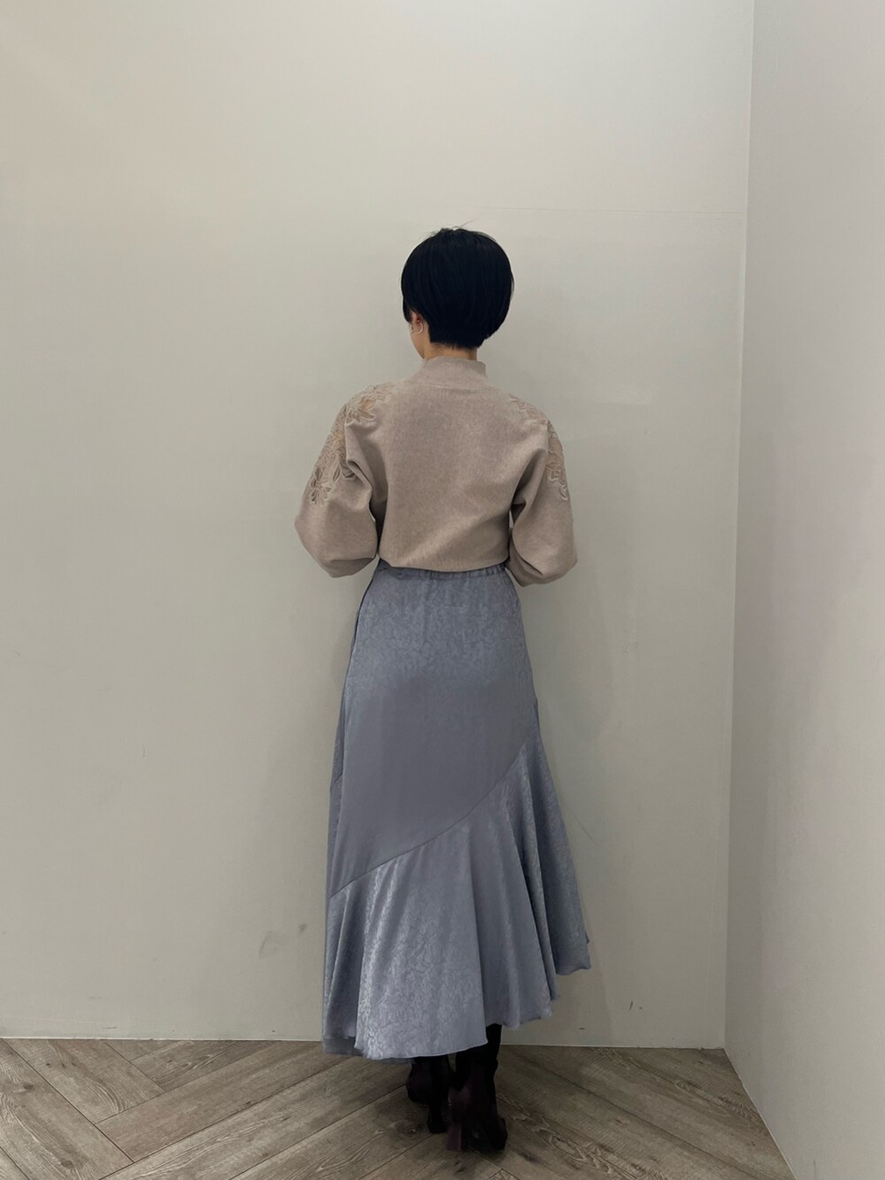 ブルー系のスカート、レッド系のブーツ、グレー系のニット/セーターを着用したレディースの冬コーディネートの2枚目の写真