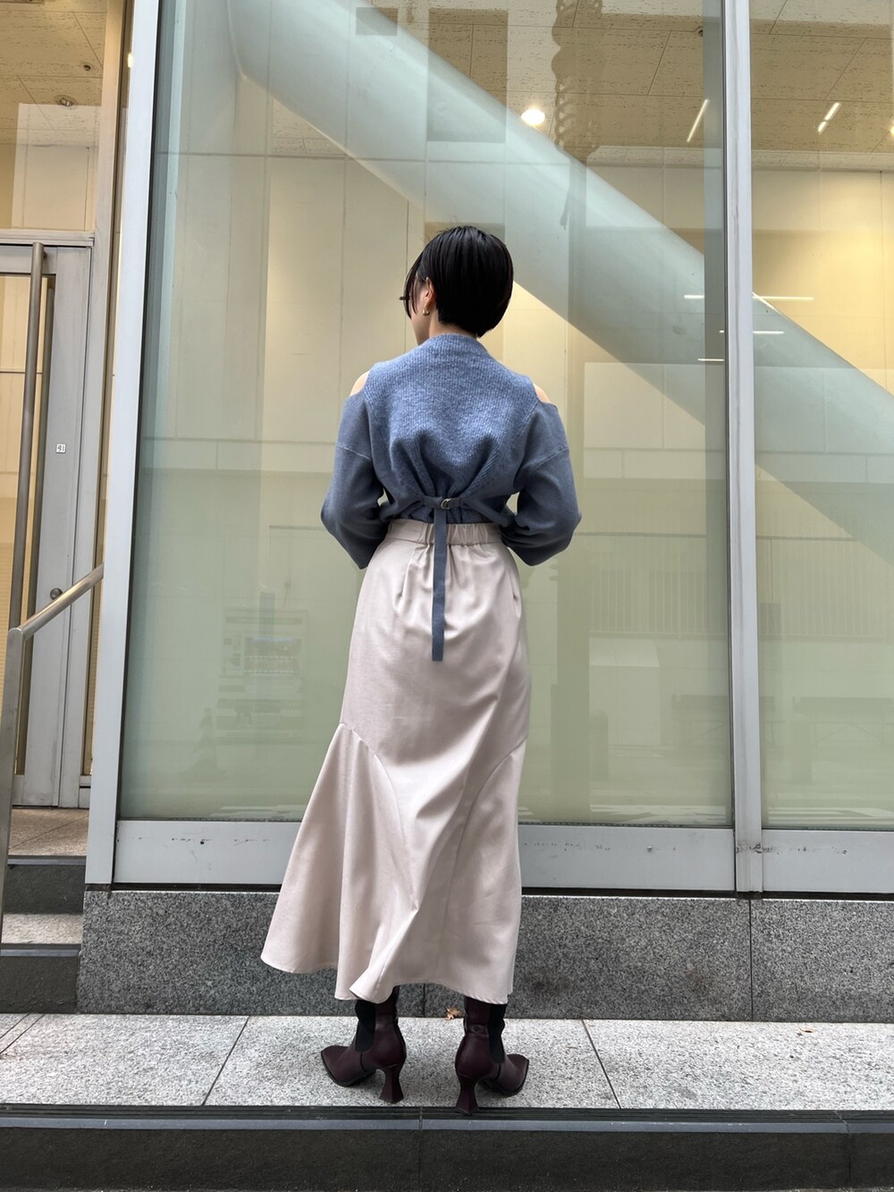 レッド系のブーツ、グレー系のスカート、ブラック系のその他アウターを着用したレディースの冬コーディネートの7枚目の写真