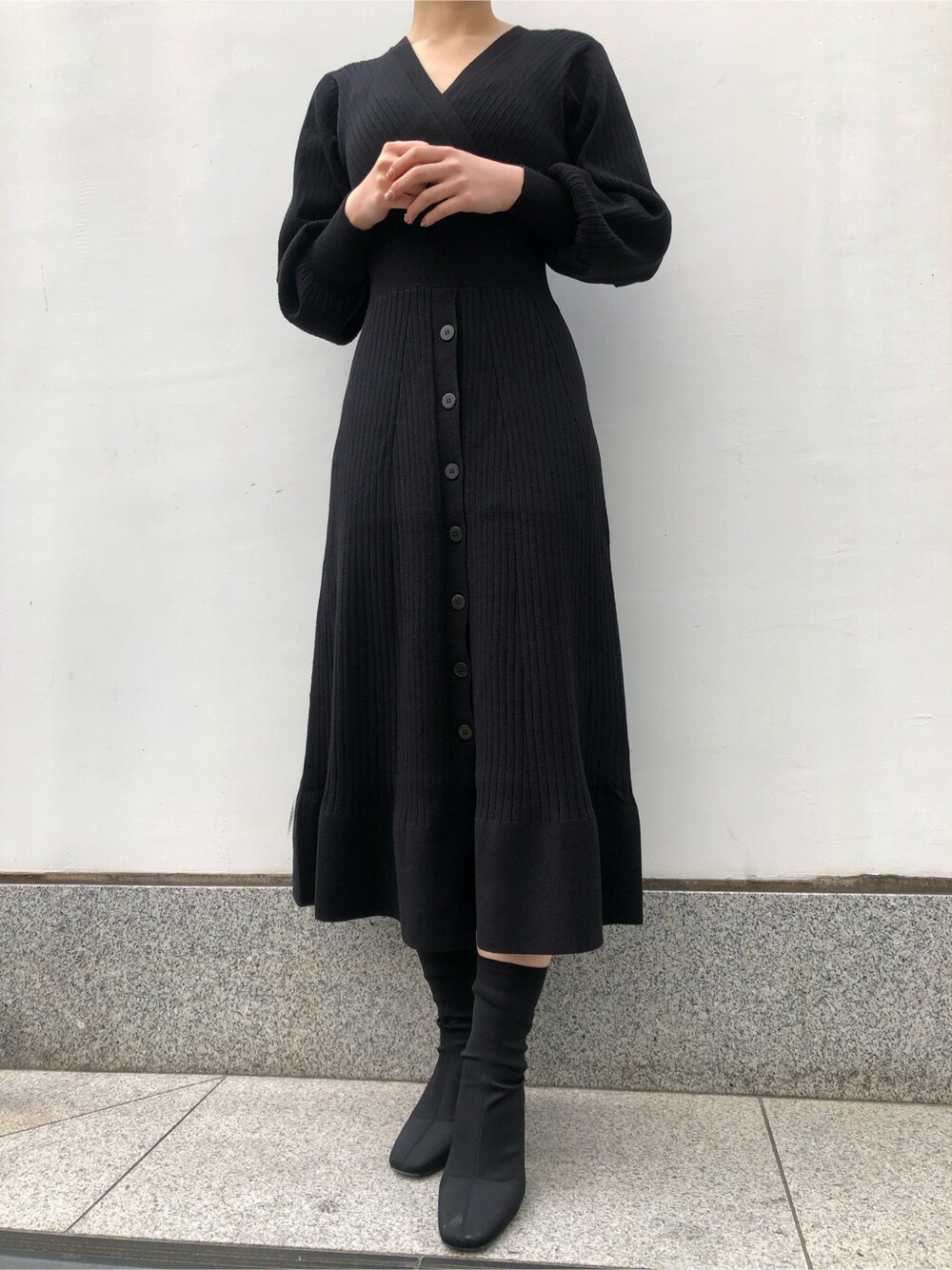 ブラック系のワンピース、ゴールド系のピアス（両耳用）を着用したレディースの冬コーディネートの4枚目の写真