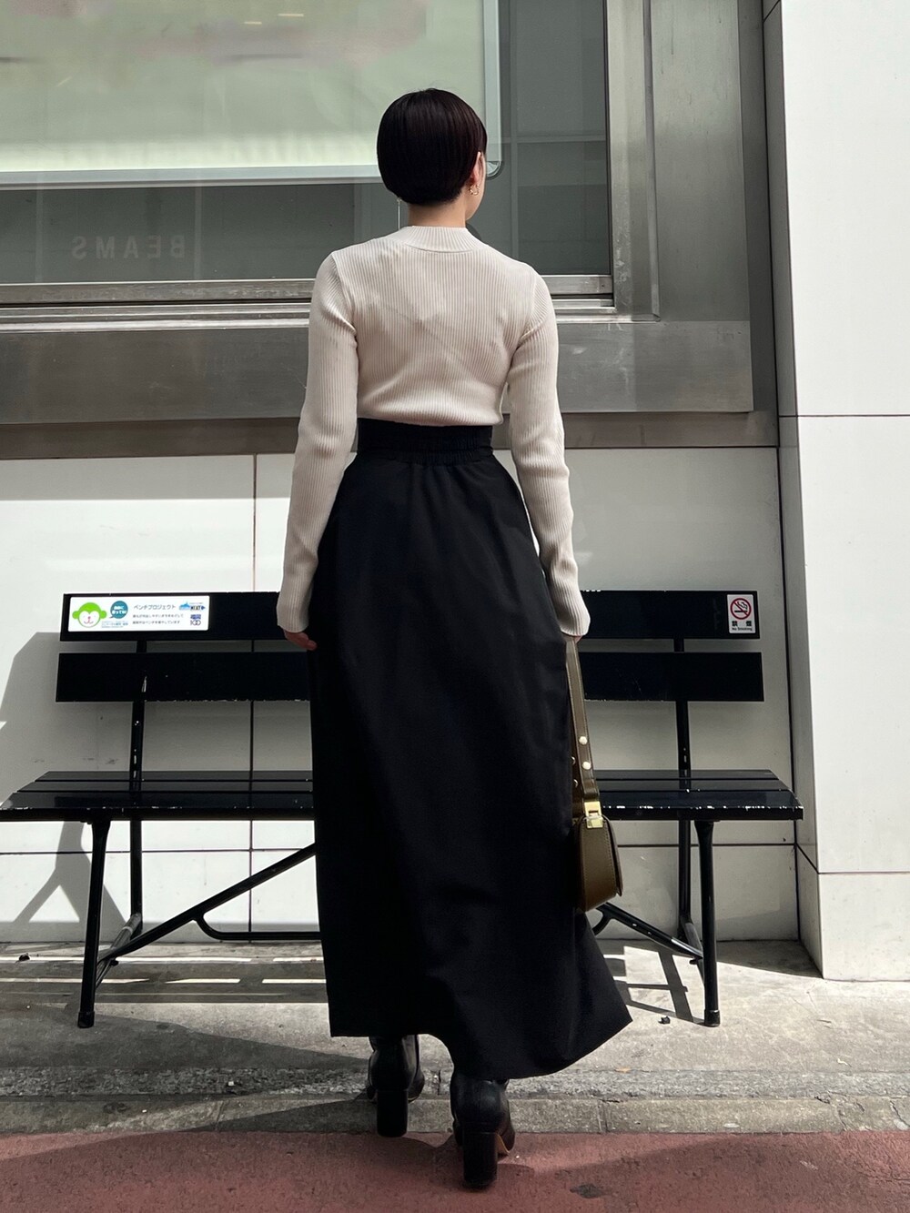 ホワイト系のニット/セーター、ブラック系のブーツ、ブラック系のスカートを着用したレディースの秋コーディネートの3枚目の写真