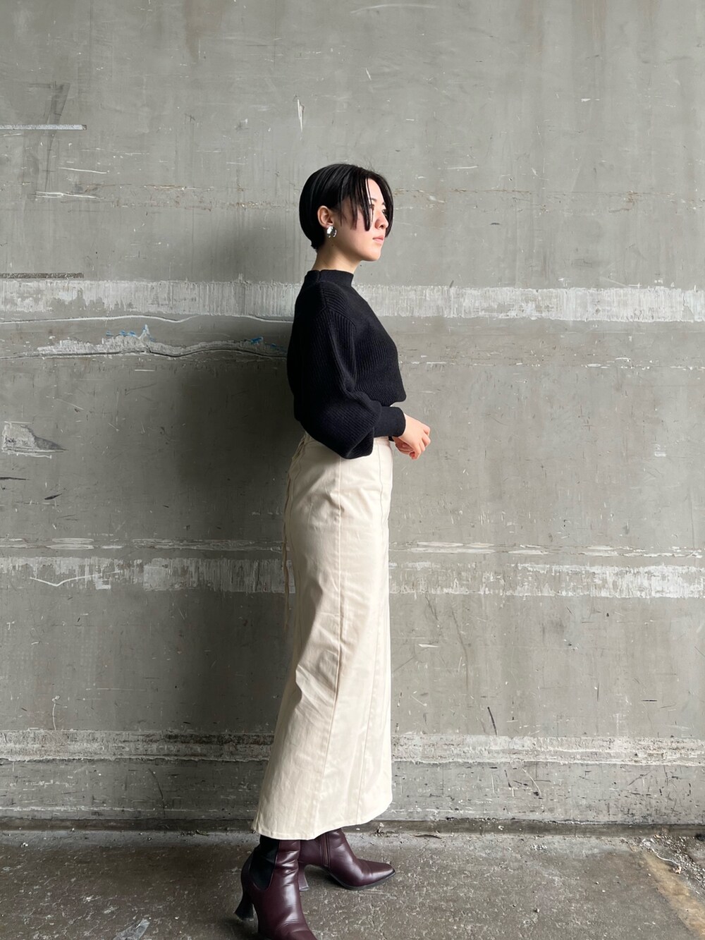 レッド系のブーツ、ホワイト系のスカート、ブラウン系のブルゾンを着用したレディースの冬コーディネートの4枚目の写真