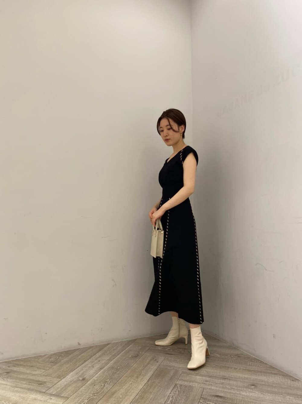 ホワイト系のショルダーバッグ、ブラック系のワンピース、ホワイト系のその他シューズを着用したレディースの夏コーディネートの2枚目の写真