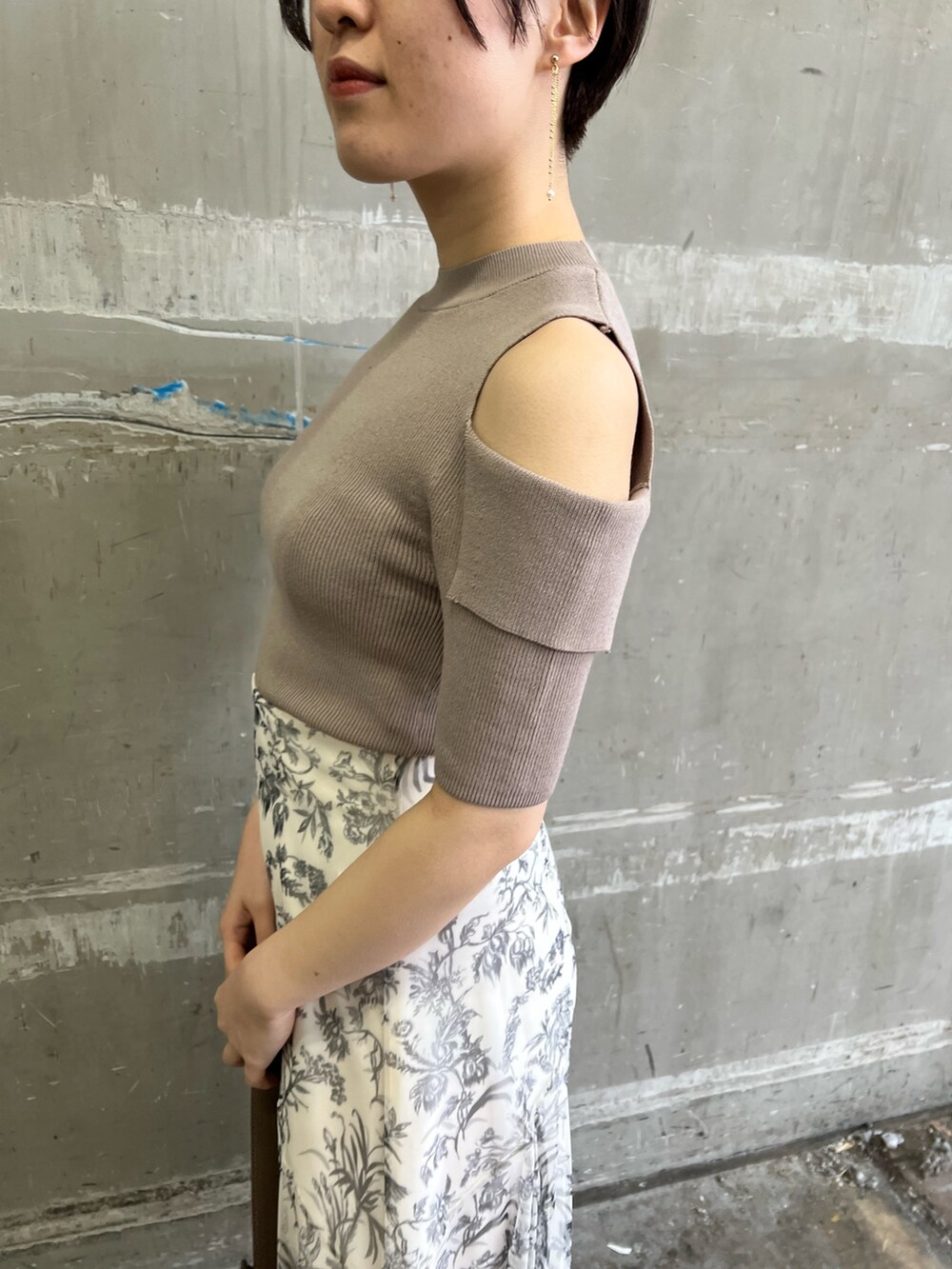 ベージュ系のノーカラーコート、ホワイト系のスカート、ベージュ系のサンダルを着用したレディースの冬コーディネートの8枚目の写真