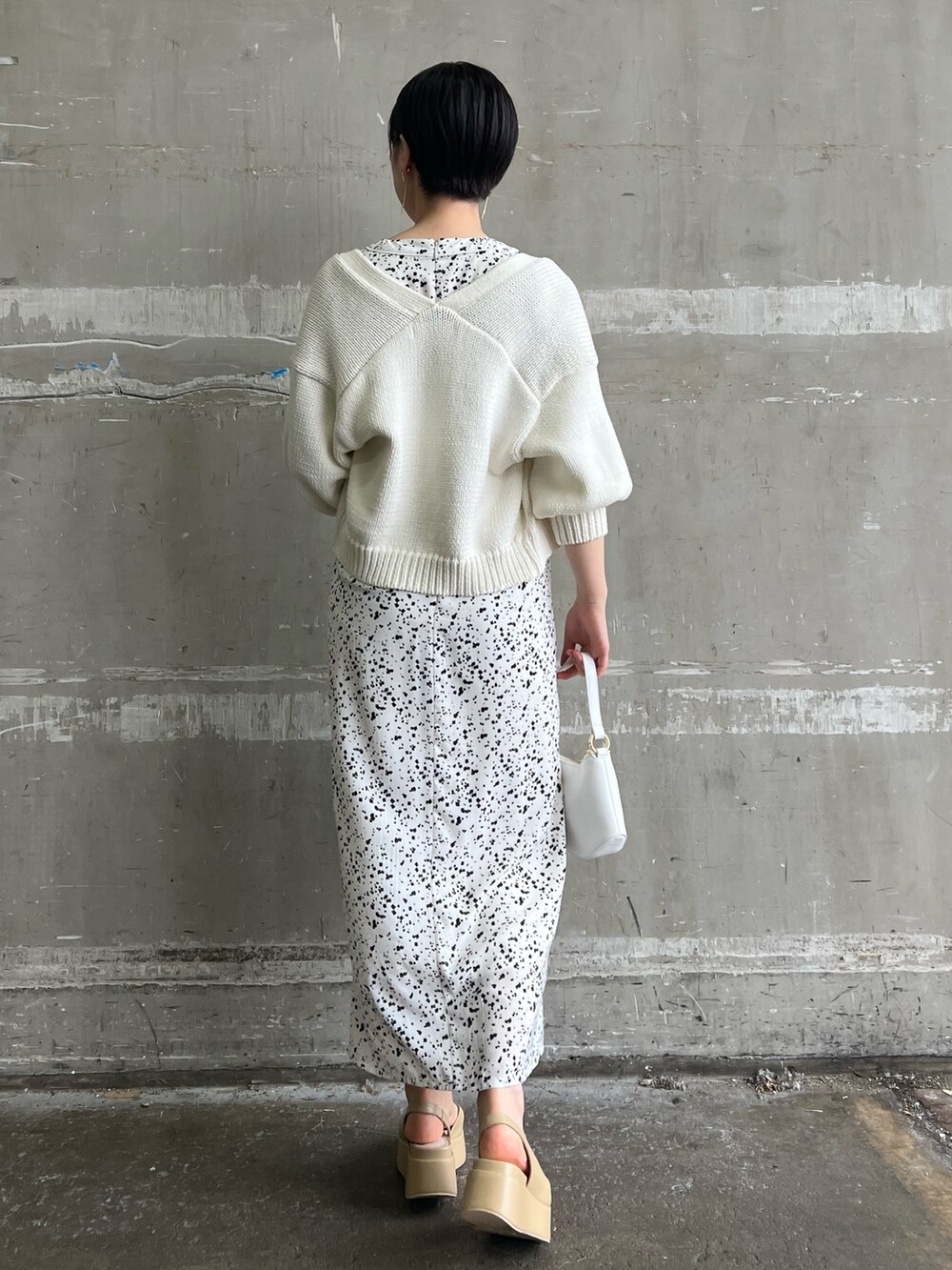 ホワイト系のワンピース、ホワイト系のカーディガン/ボレロ、ベージュ系のサンダルを着用したレディースの春コーディネートの3枚目の写真