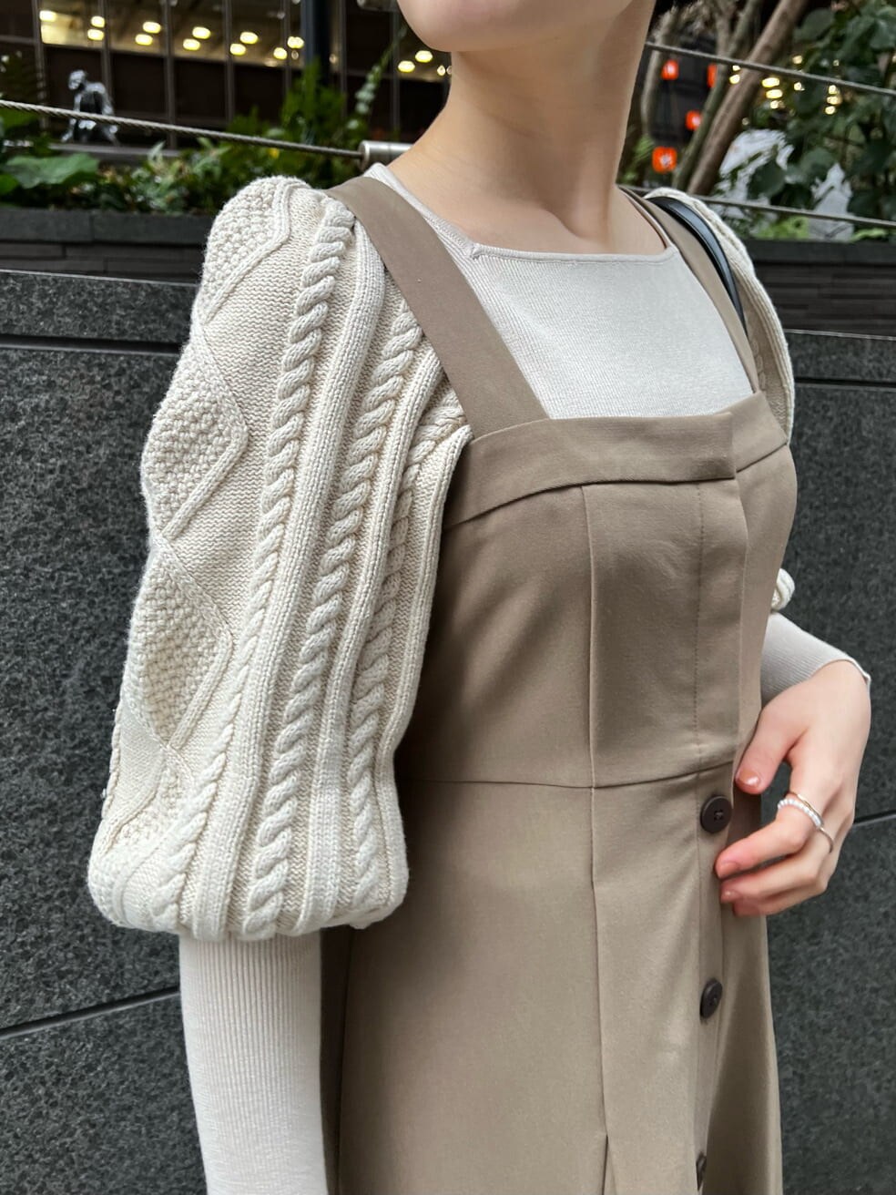 ホワイト系のハンドバッグ、ベージュ系のその他シューズ、ホワイト系のニット/セーターを着用したレディースの冬コーディネートの3枚目の写真