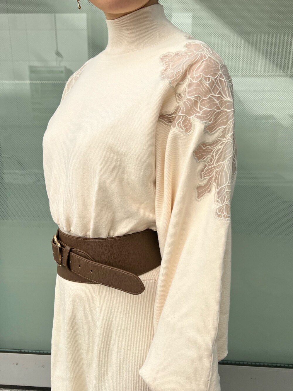 ホワイト系のハンドバッグ、ベージュ系のブーツ、ホワイト系のワンピースを着用したレディースの冬コーディネートの5枚目の写真