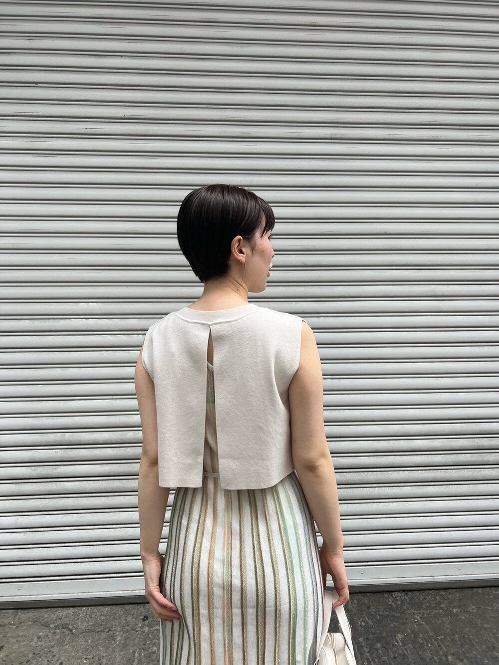 ホワイト系のショルダーバッグ、ベージュ系のサンダル、ホワイト系のワンピースを着用したレディースの春コーディネートの6枚目の写真