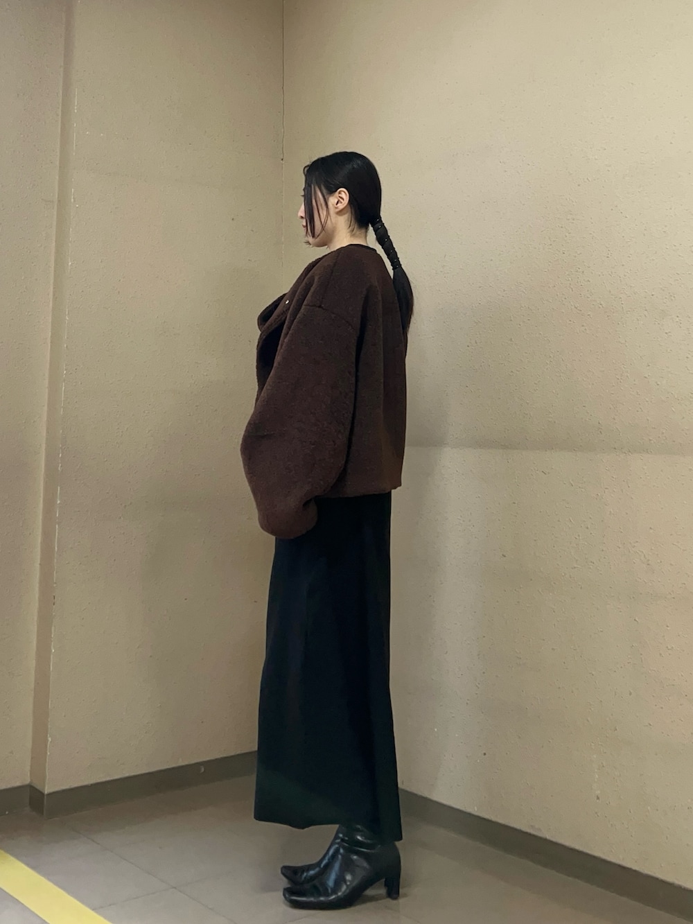 ブラック系のワンピース、ブラウン系のブルゾンを着用したレディースの冬コーディネートの3枚目の写真