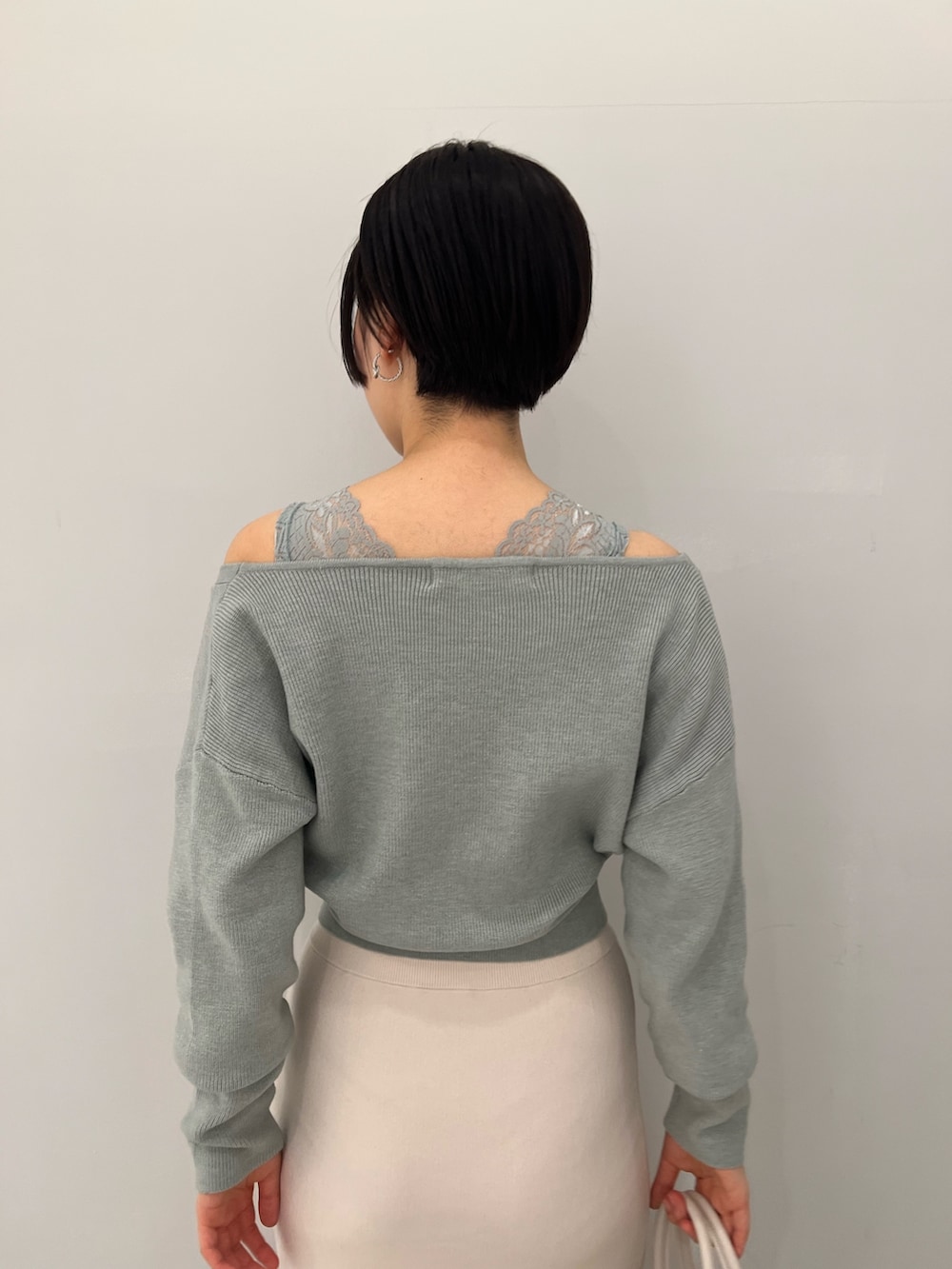 レッド系のブーツ、ホワイト系のハンドバッグ、ホワイト系のスカートを着用したレディースの冬コーディネートの6枚目の写真