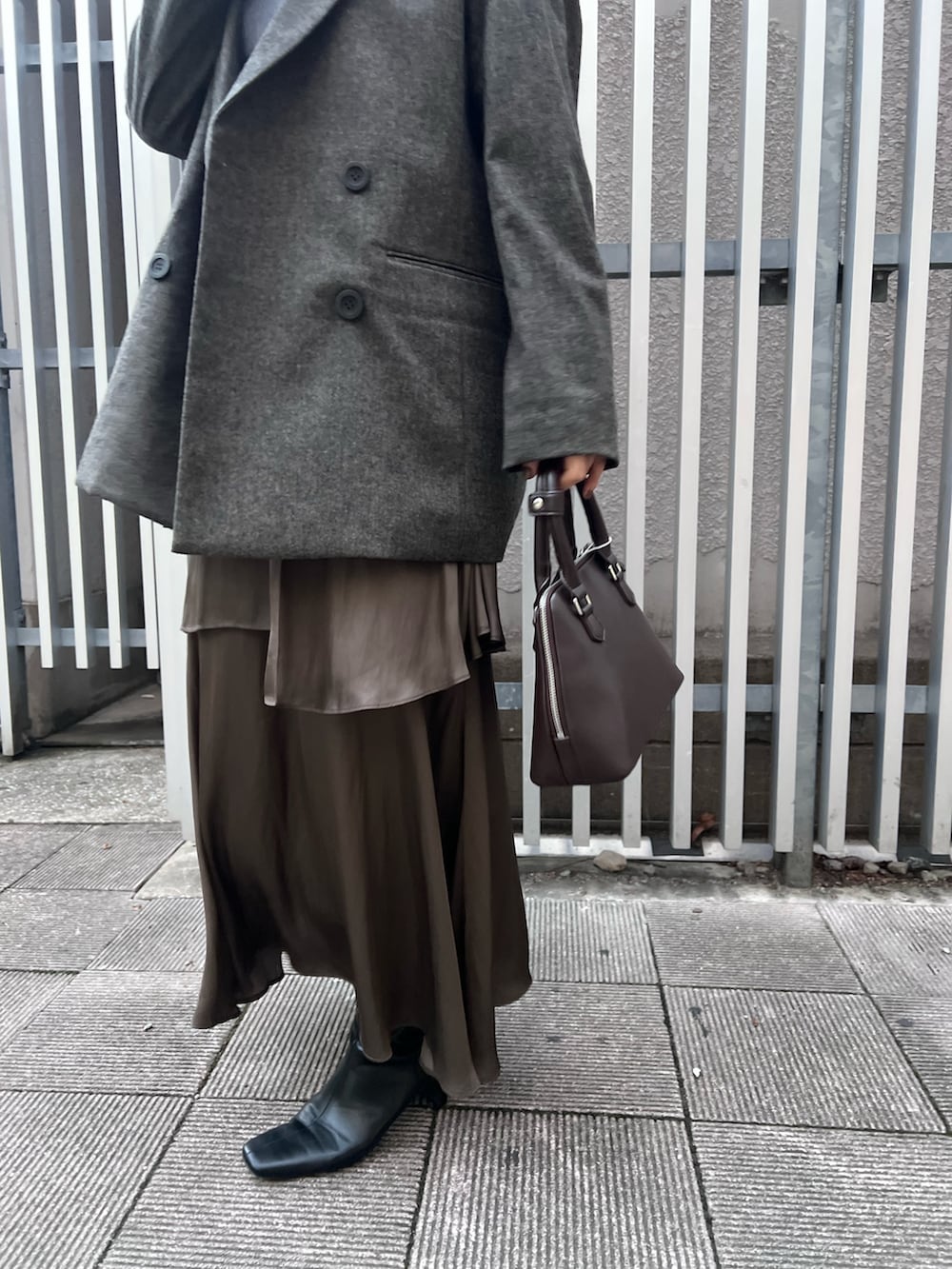 ブラック系のブーツ、ブルー系のニット/セーター、ブラウン系のテーラードジャケットを着用したレディースの秋コーディネートの6枚目の写真