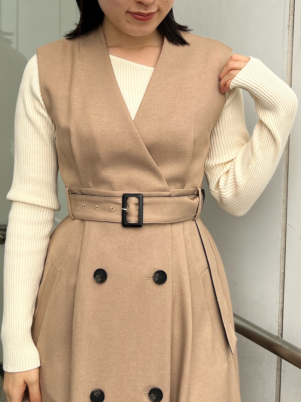 ベージュ系のトレンチコート、ホワイト系のショルダーバッグ、ホワイト系のニット/セーターを着用したレディースの秋コーディネートの8枚目の写真