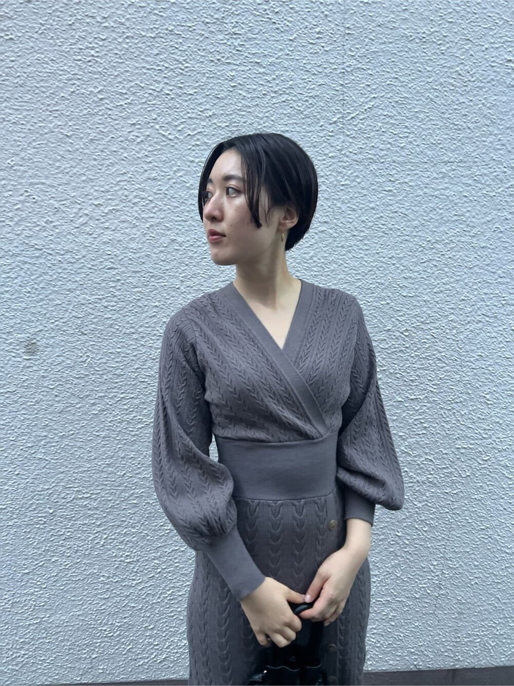 ブラウン系のワンピース、ベージュ系のブーツ、ブラック系のハンドバッグを着用したレディースの秋コーディネートの8枚目の写真