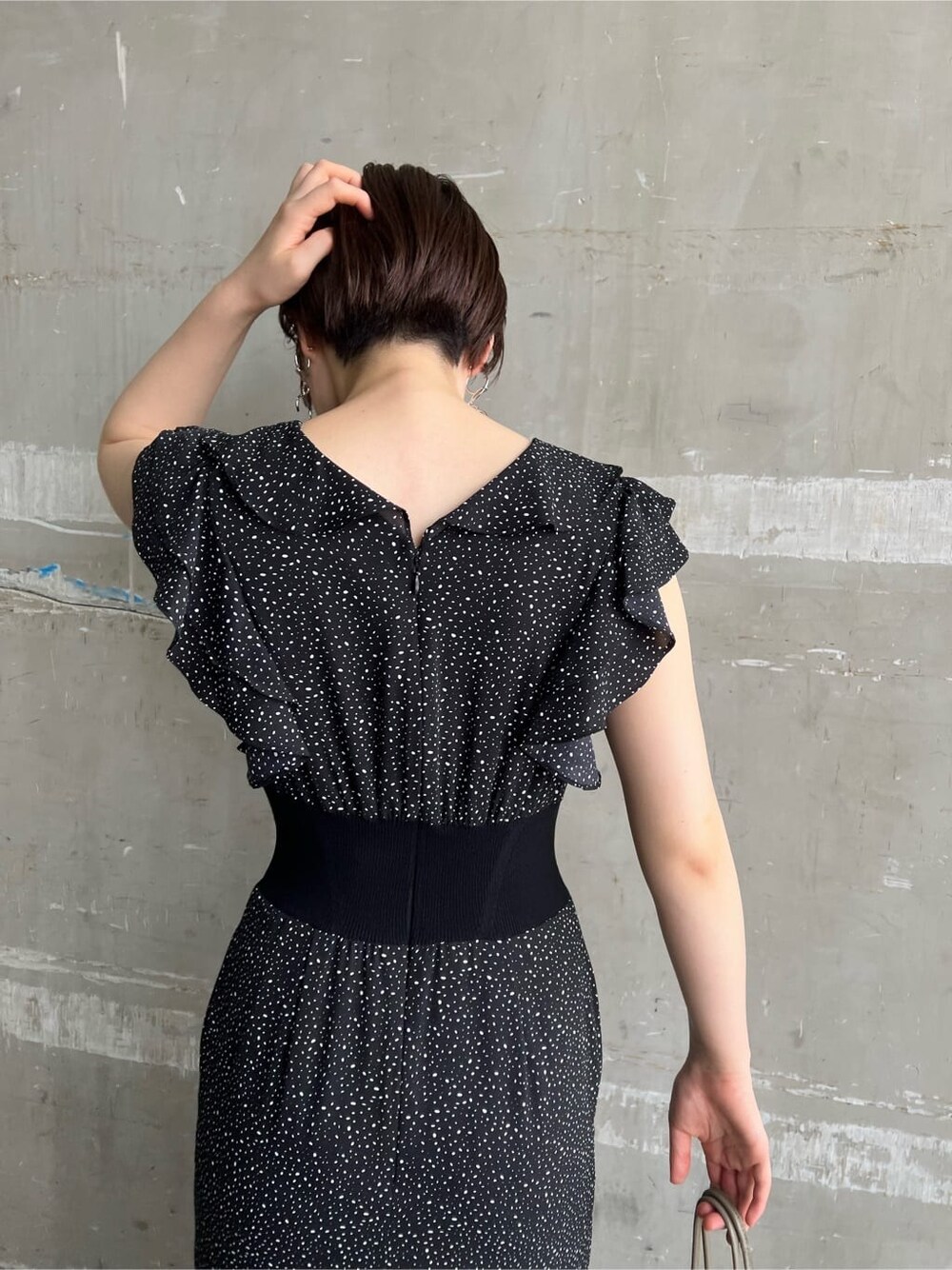 ベージュ系のハンドバッグ、ブラウン系のパンプス、ブラック系のワンピースを着用したレディースの夏コーディネートの5枚目の写真