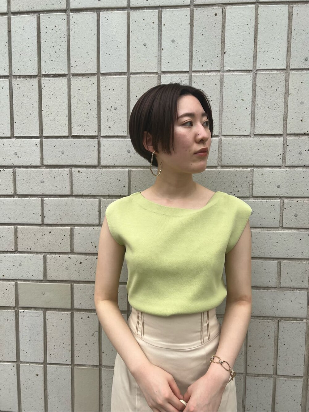 ホワイト系のハンドバッグ、グリーン系のサンダル、ホワイト系のスカートを着用したレディースの春コーディネートの4枚目の写真