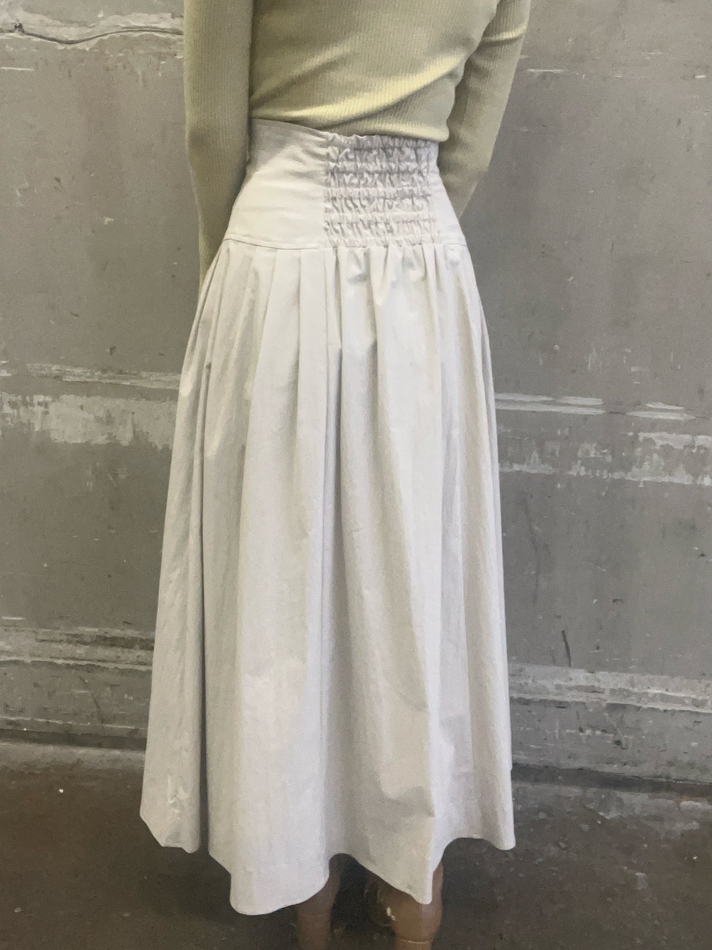 ベージュ系のブーツ、ホワイト系のスカート、グリーン系のニット/セーターを着用したレディースの冬コーディネートの9枚目の写真