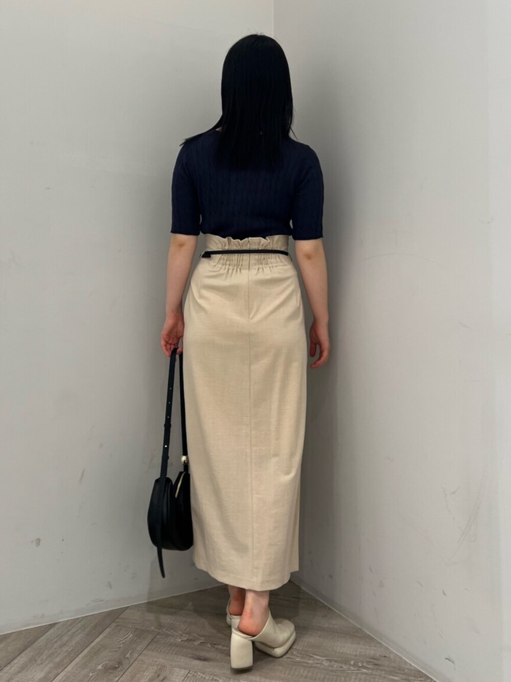 ブルー系のニット/セーター、ホワイト系のサンダル、ベージュ系のスカートを着用したレディースの春コーディネートの3枚目の写真