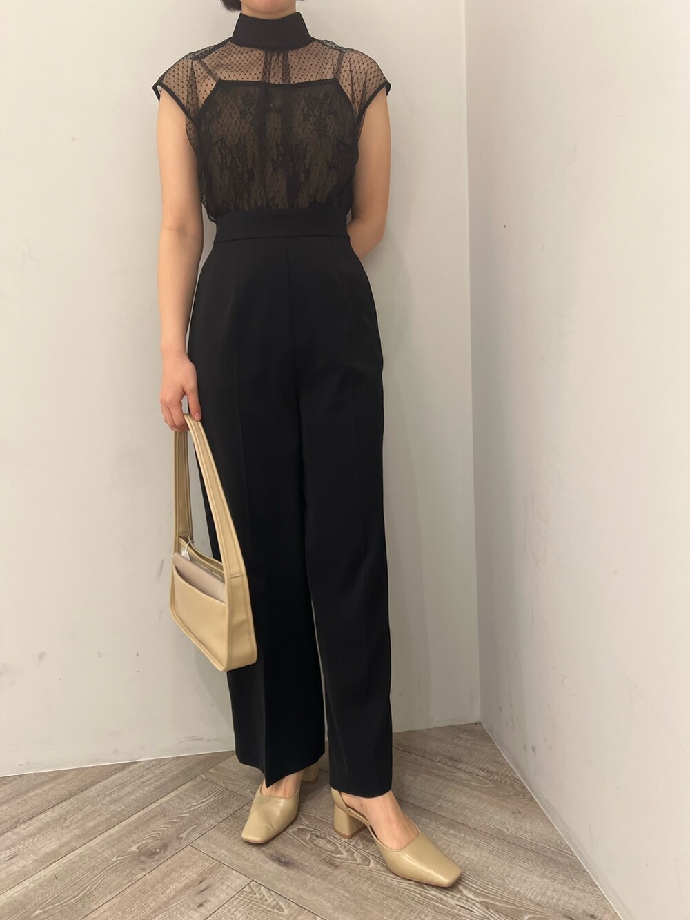ベージュ系のパンプス、ブラック系のパンツドレス、ベージュ系のハンドバッグを着用したレディースの春コーディネートの6枚目の写真
