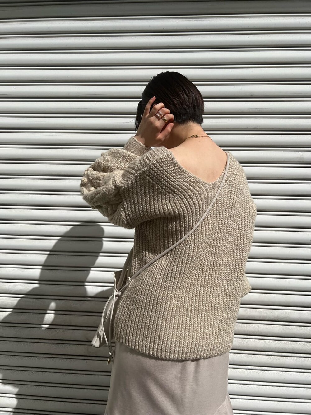 ベージュ系のブーツ、ホワイト系のニット/セーター、グレー系のスカートを着用したレディースの秋コーディネートの6枚目の写真