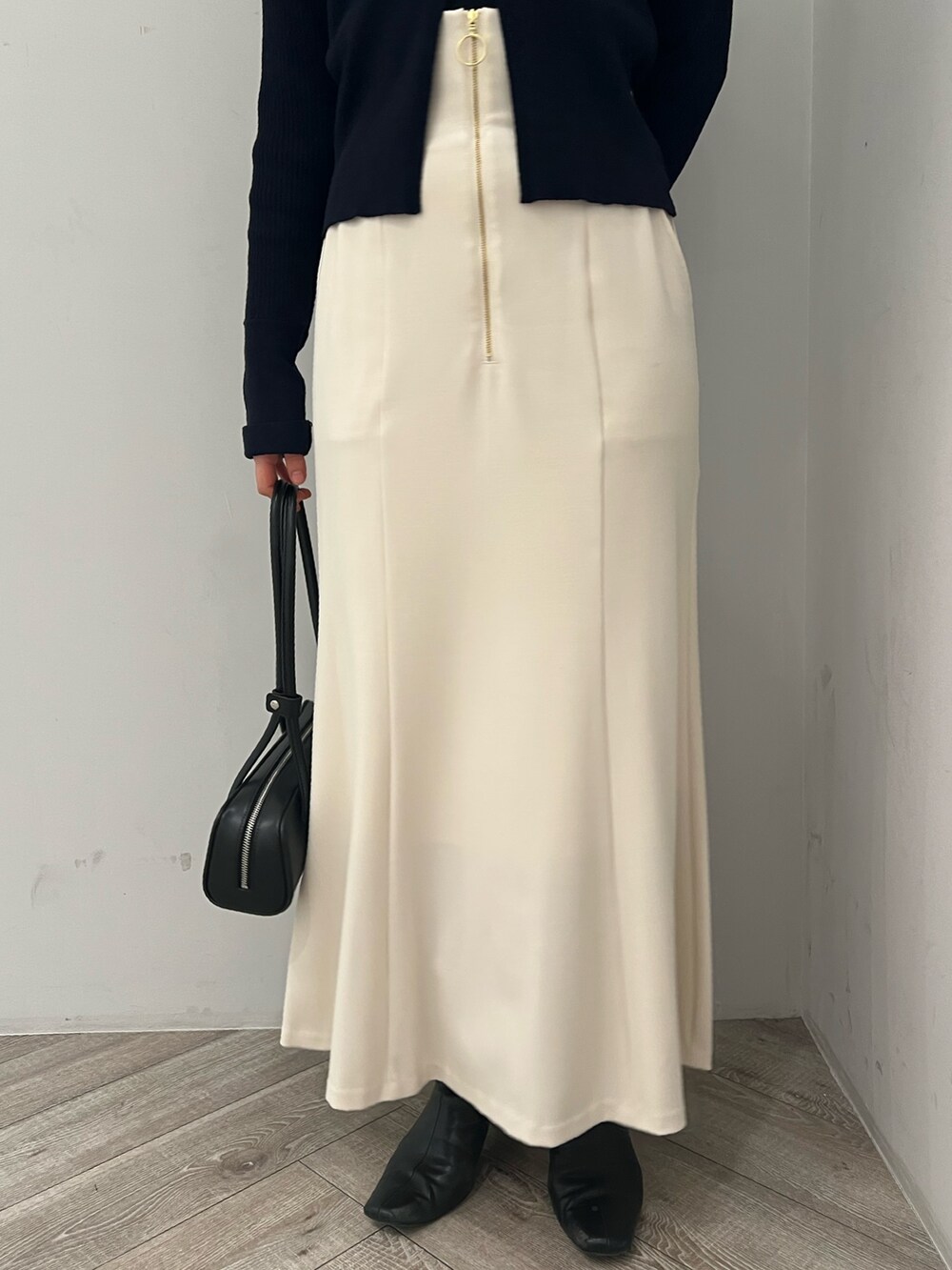 ブルー系のアンサンブル、ホワイト系のスカートを着用したレディースの冬コーディネートの5枚目の写真