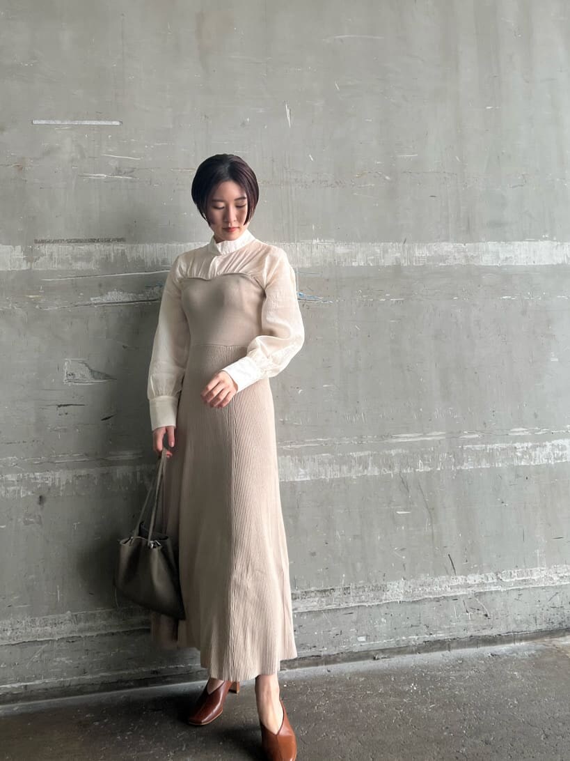 ホワイト系のトレンチコート、ベージュ系のワンピース、ベージュ系のハンドバッグを着用したレディースの春コーディネートの6枚目の写真