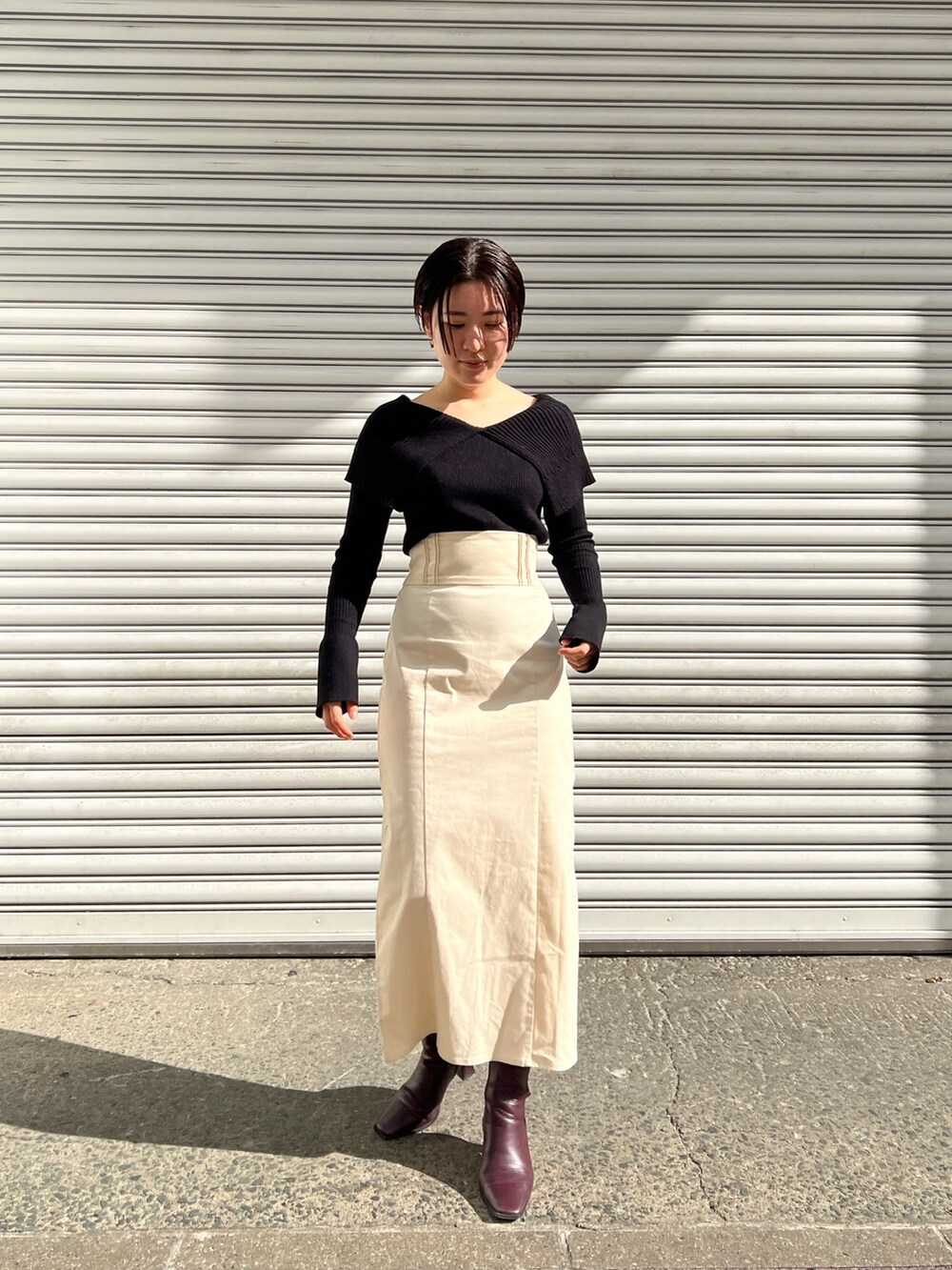 レッド系のブーツ、ホワイト系のスカート、ホワイト系のカーディガン/ボレロを着用したレディースの冬コーディネートの9枚目の写真