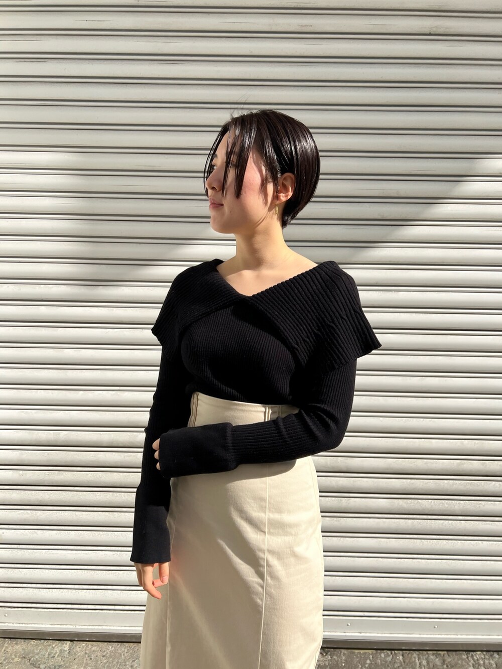 レッド系のブーツ、ホワイト系のスカート、ホワイト系のカーディガン/ボレロを着用したレディースの冬コーディネートの4枚目の写真