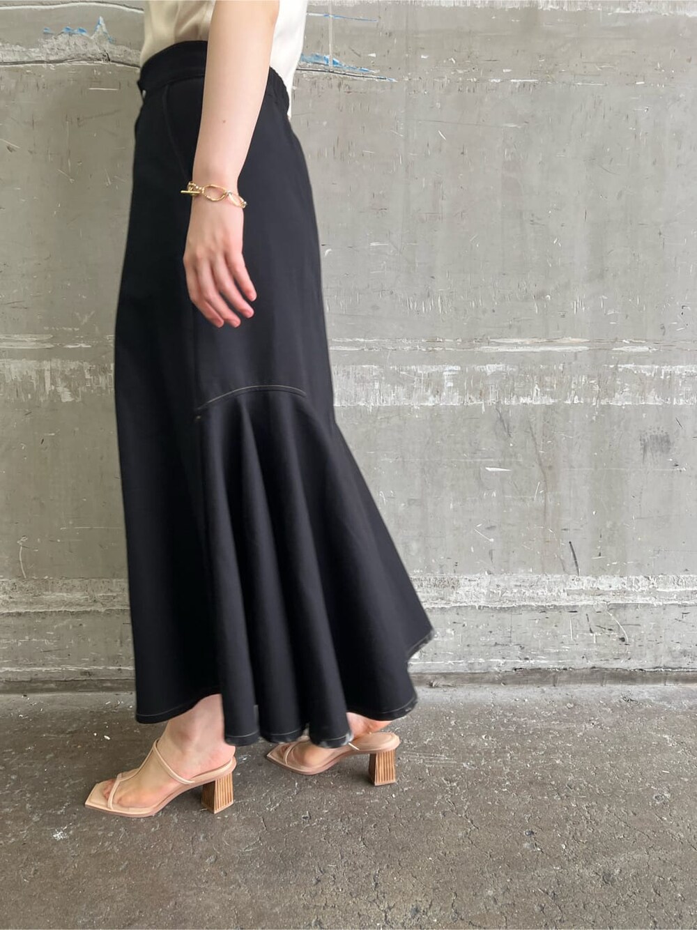 ベージュ系のハンドバッグ、ブラック系のスカート、ホワイト系のニット/セーターを着用したレディースの夏コーディネートの9枚目の写真