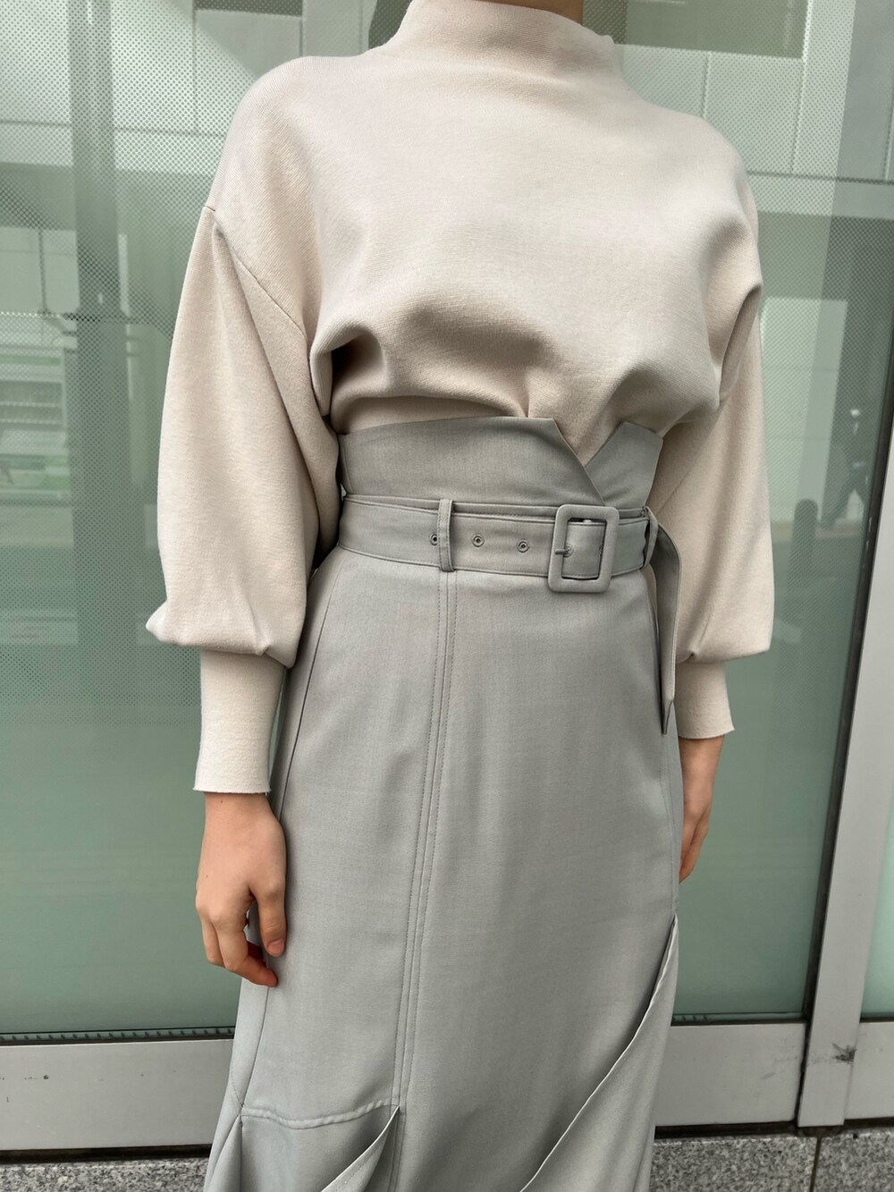 ベージュ系のブーツ、グリーン系のスカート、ホワイト系のニット/セーターを着用したレディースの冬コーディネートの5枚目の写真