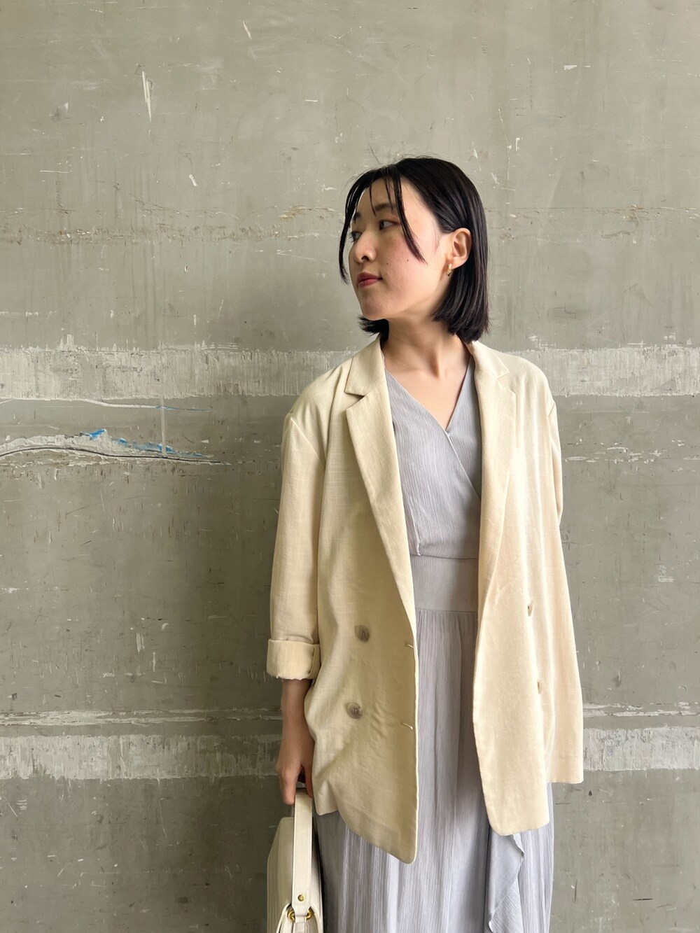 ブラック系のサンダル、ホワイト系のショルダーバッグ、ベージュ系のテーラードジャケットを着用したレディースの春コーディネートの3枚目の写真